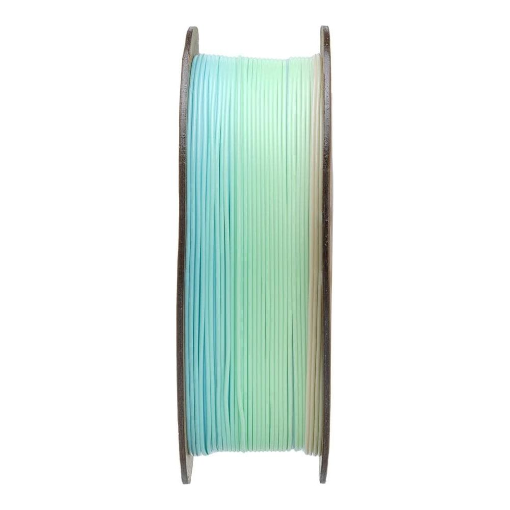 Una bobina di filamento multicolore nei toni del blu, verde e crema.