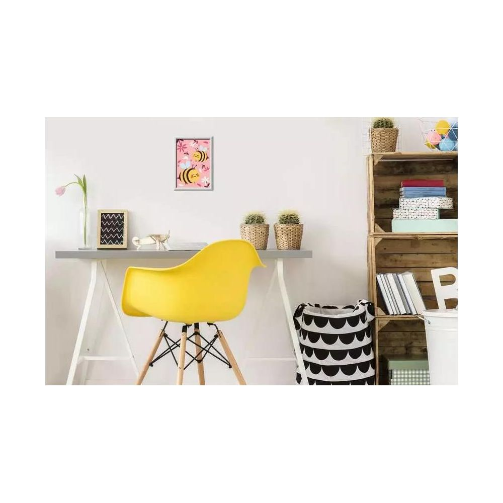 Una silla amarilla delante de un escritorio con un cuadro de abejas y flores.