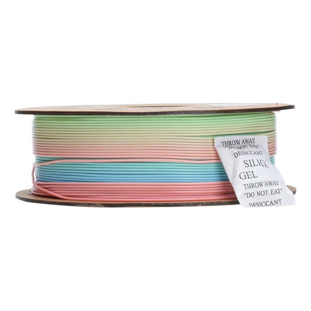 Una bobina di filamento multicolore per la stampa 3D con una bustina di gel di silice.