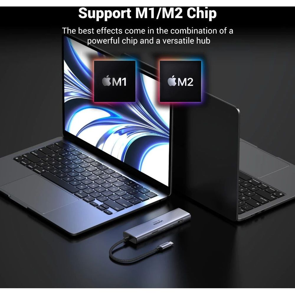 Srebrny hub USB przed dwoma laptopami z wyświetlanymi na ekranie chipami M1 i M2.