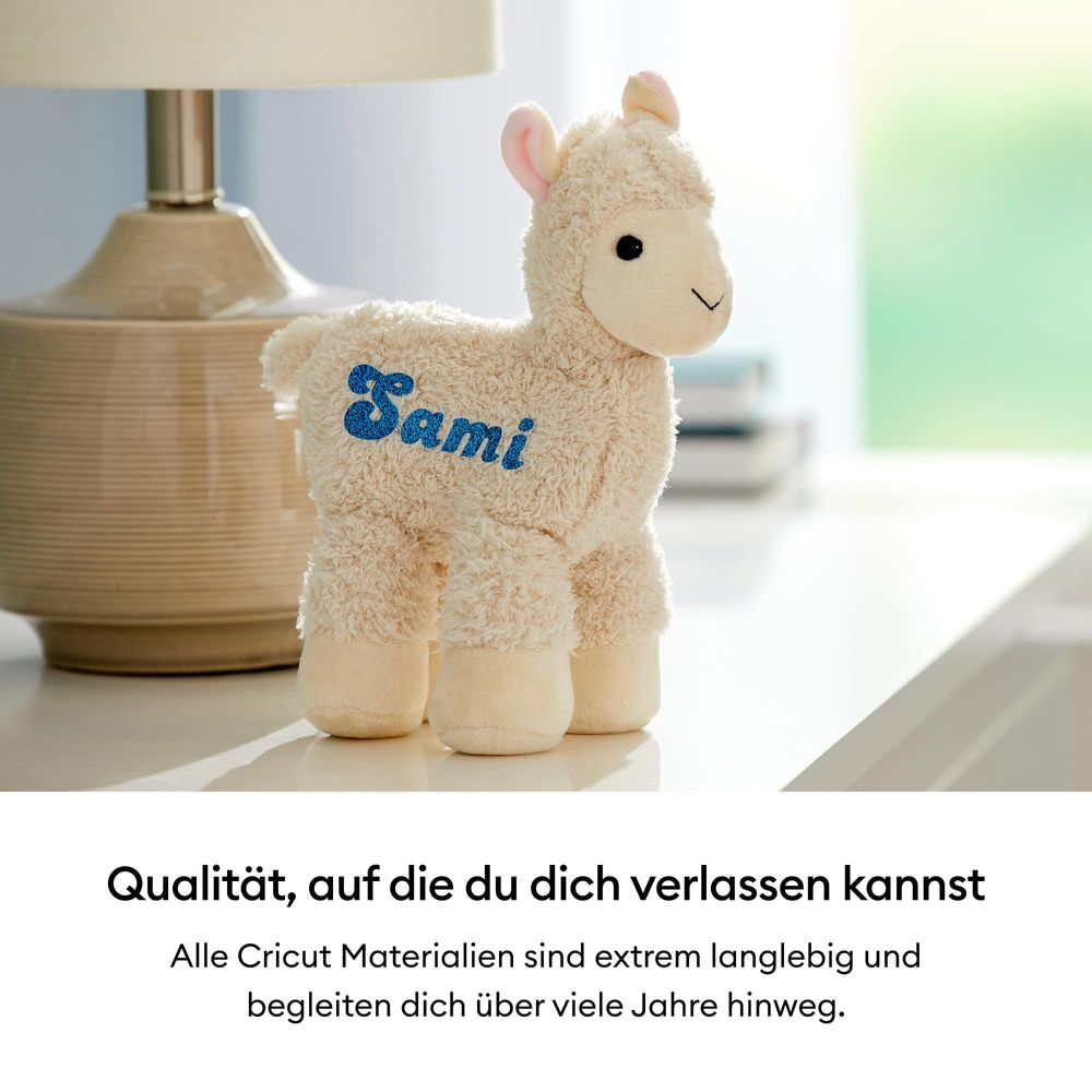 Ein cremefarbener Plüsch-Lama mit dem Namen Sami. Steht auf einem Tisch.