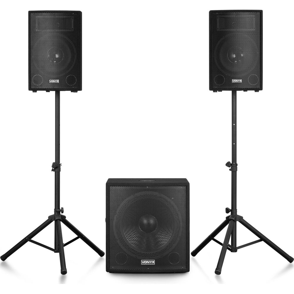 Dos altavoces negros en soportes, un subwoofer delante.