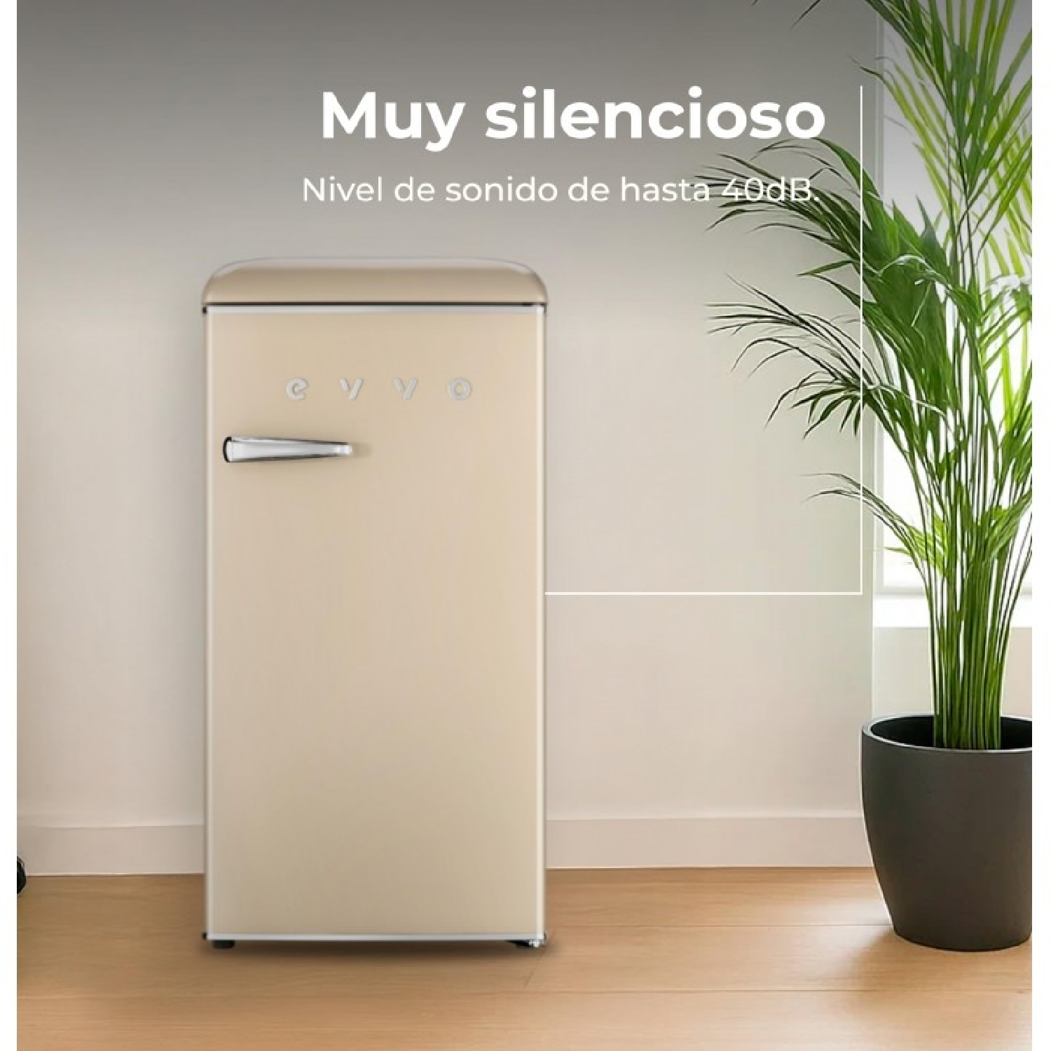 Un refrigerador color crema con asa plateada junto a una planta en maceta.