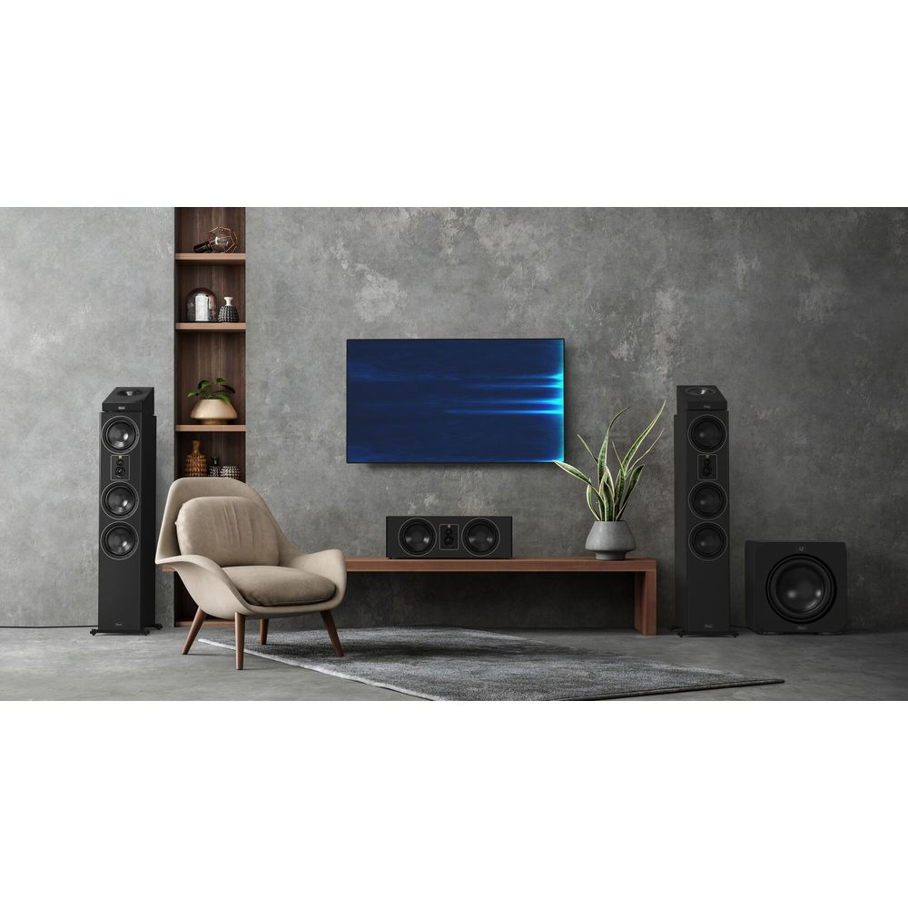 Schwarze Lautsprecher und Fernseher in einem modernen Wohnzimmer mit Sessel und Regal.
