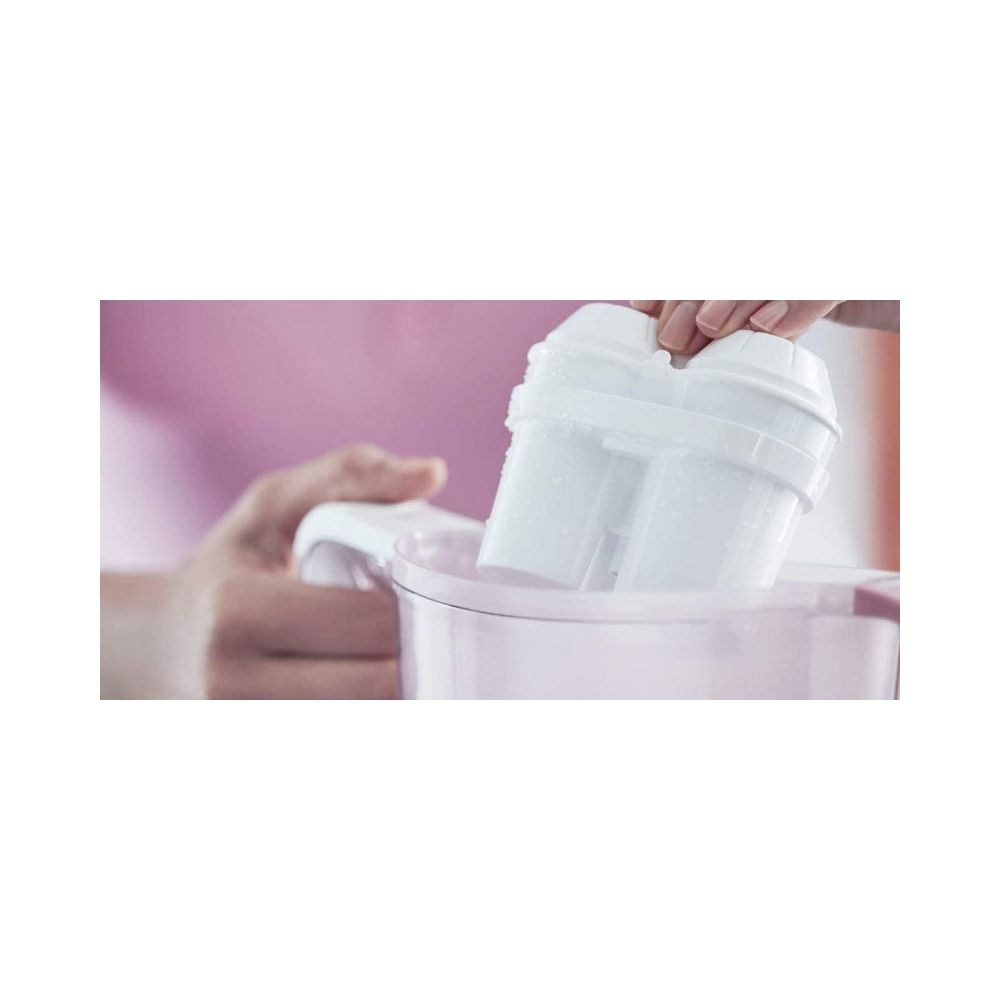 Eine Hand setzt einen weißen Wasserfilter in eine Karaffe ein.