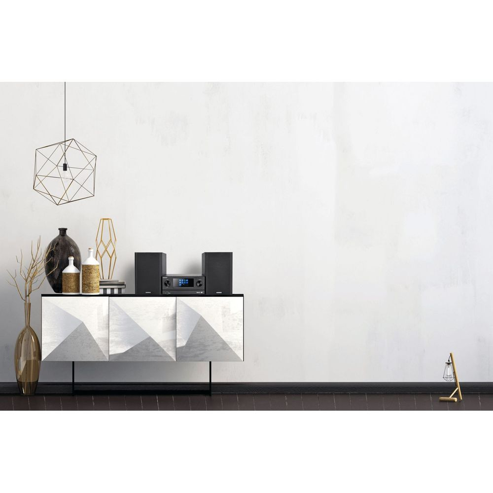 Un système stéréo noir sur un meuble blanc avec des décorations.