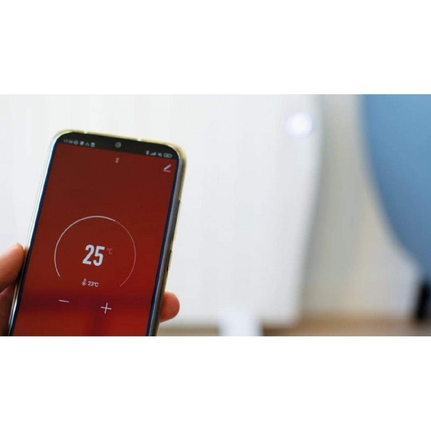 Una mano sostiene un teléfono inteligente que muestra 25°C en una pantalla roja.