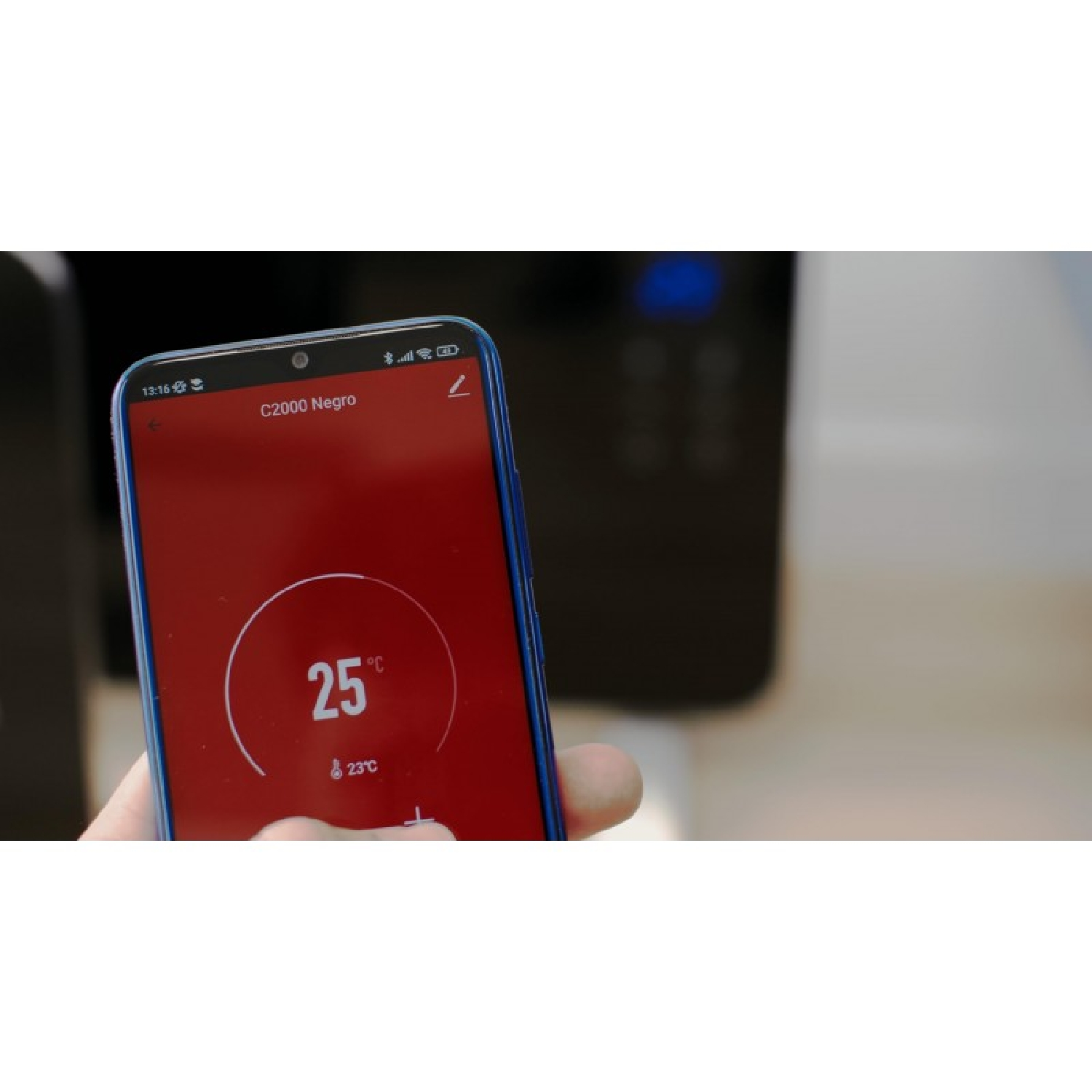 Una mano sostiene un smartphone azul con pantalla roja que muestra 25°C.