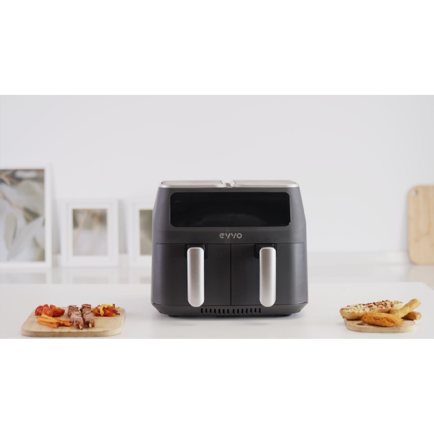 Una friggitrice ad aria nera doppia con cibo su entrambi i lati.