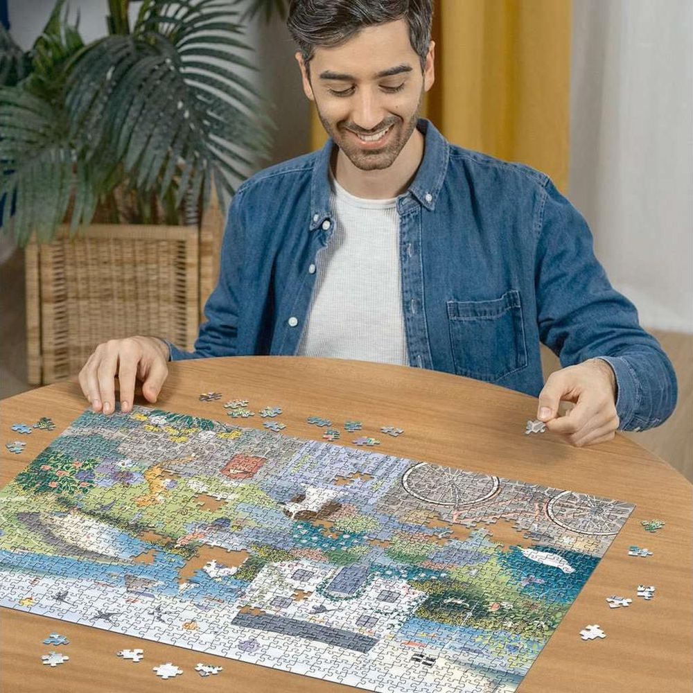 Un uomo è seduto a un tavolo di legno, mentre compone un puzzle.