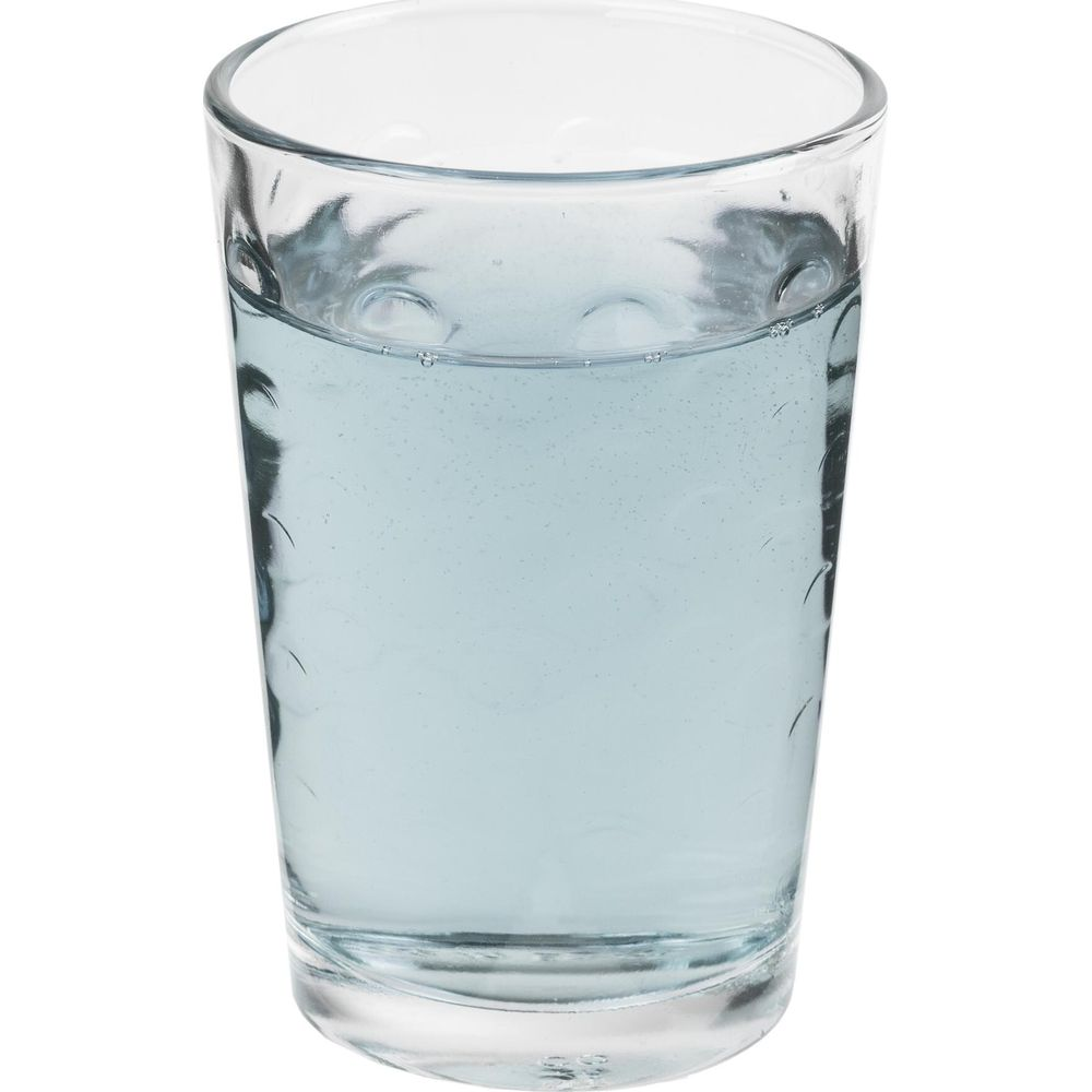 Un vaso con agua azul claro y pequeñas burbujas, sobre fondo blanco.