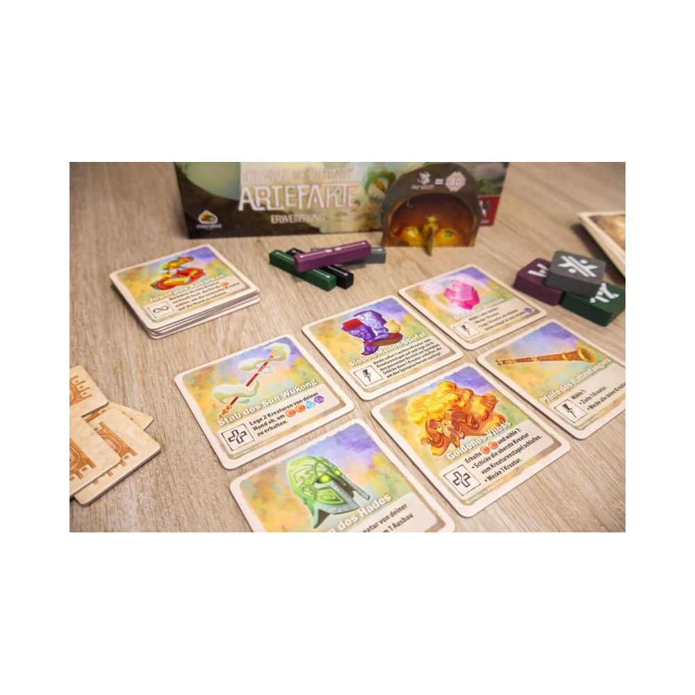 Spielkarten und Token auf Holzoberfläche. Artefakie Brettspiel sichtbar.