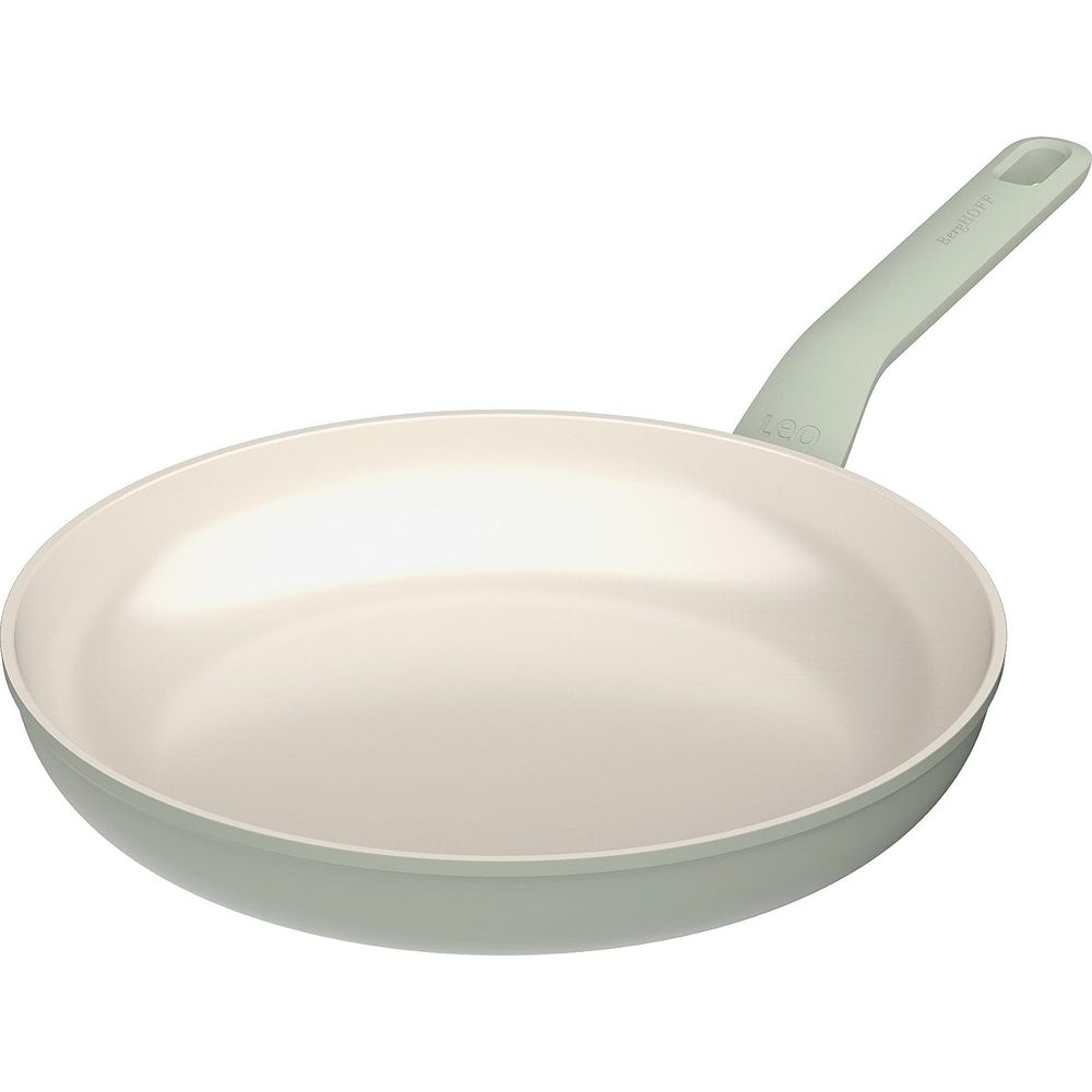 A light-colored frying pan with a light green handle on a white background.