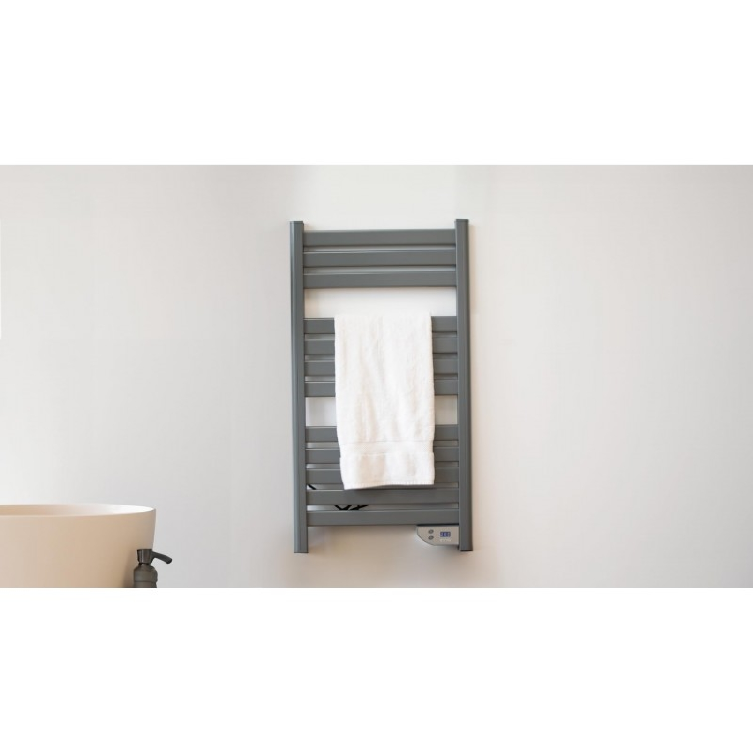 Un toallero gris con toalla blanca y bañera. Pared blanca.