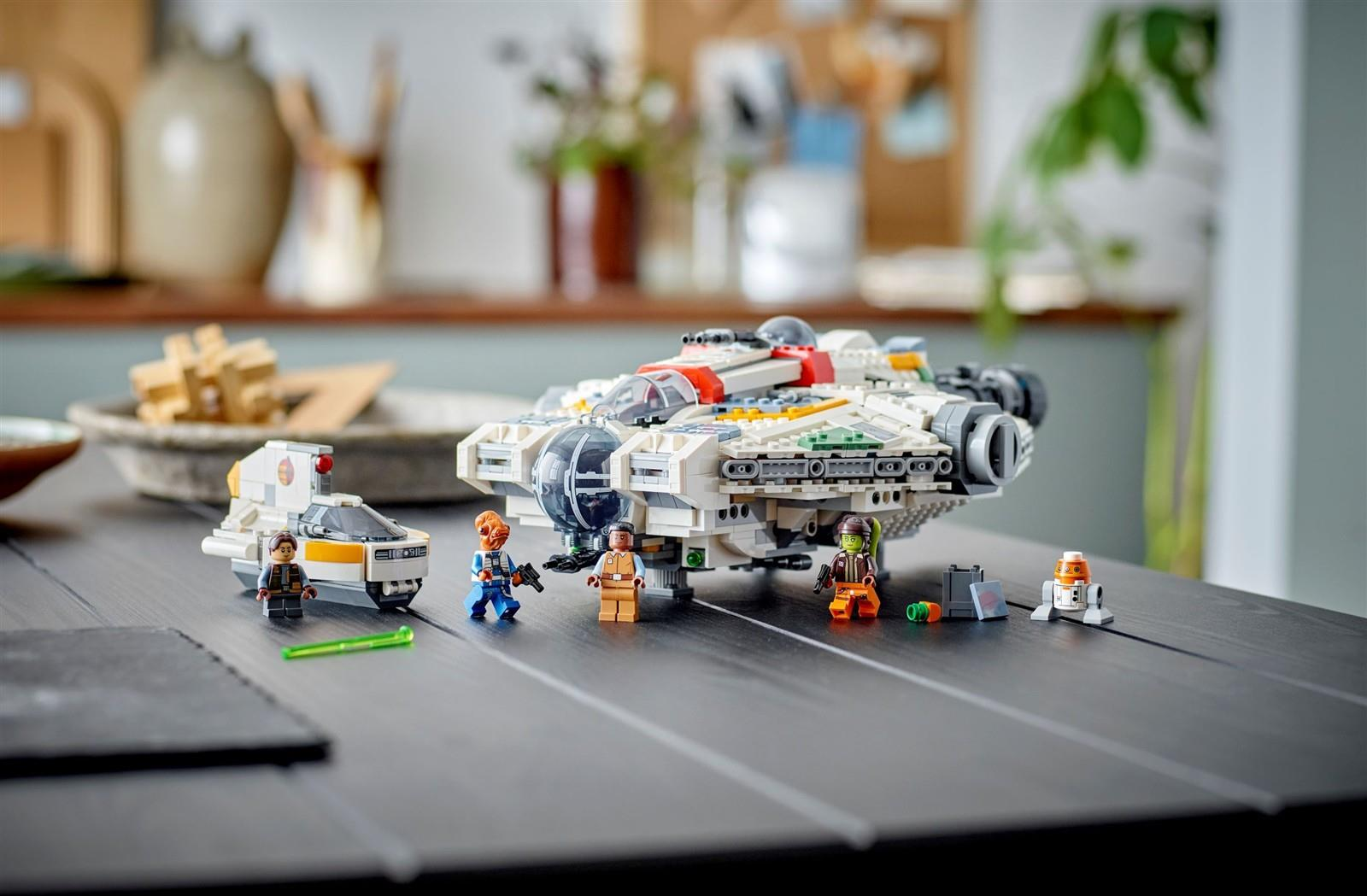 Lego-Raumschiff mit Figuren und kleinem Fahrzeug auf einem Holztisch.
