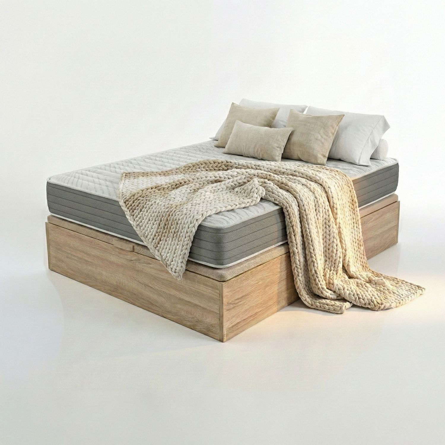 Un colchón gris con almohadas y una manta beige sobre una base de madera.