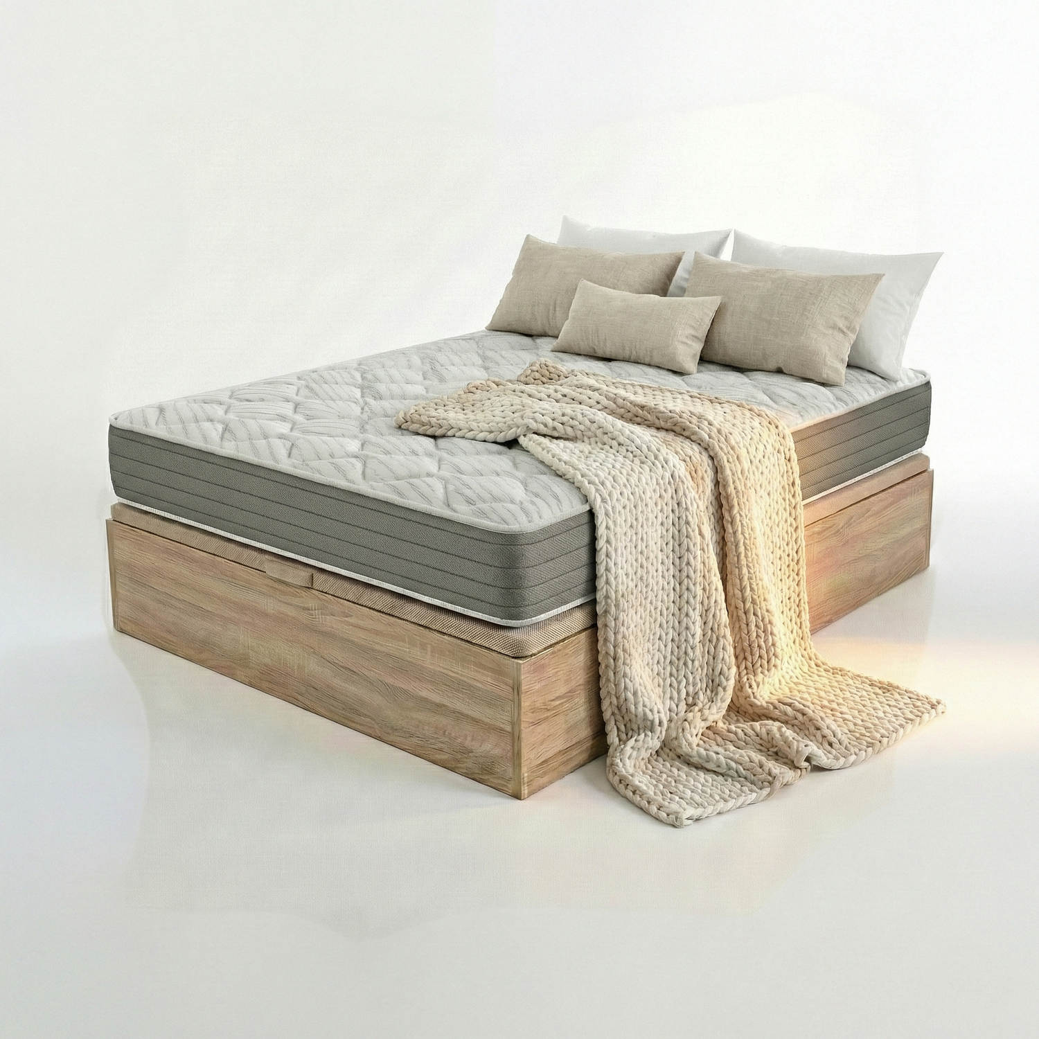 Una cama con colchón, almohadas y manta sobre un somier de madera.