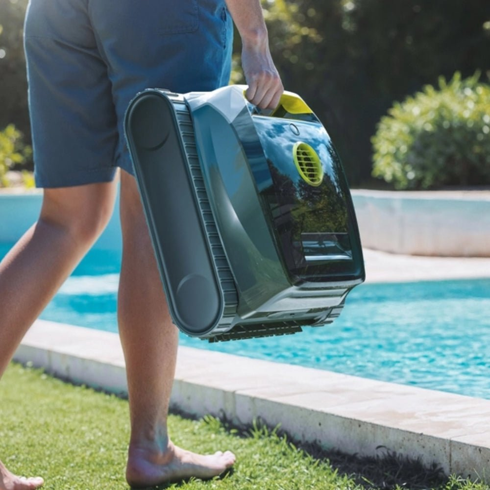 Persona lleva limpiador de piscina junto a piscina azul.