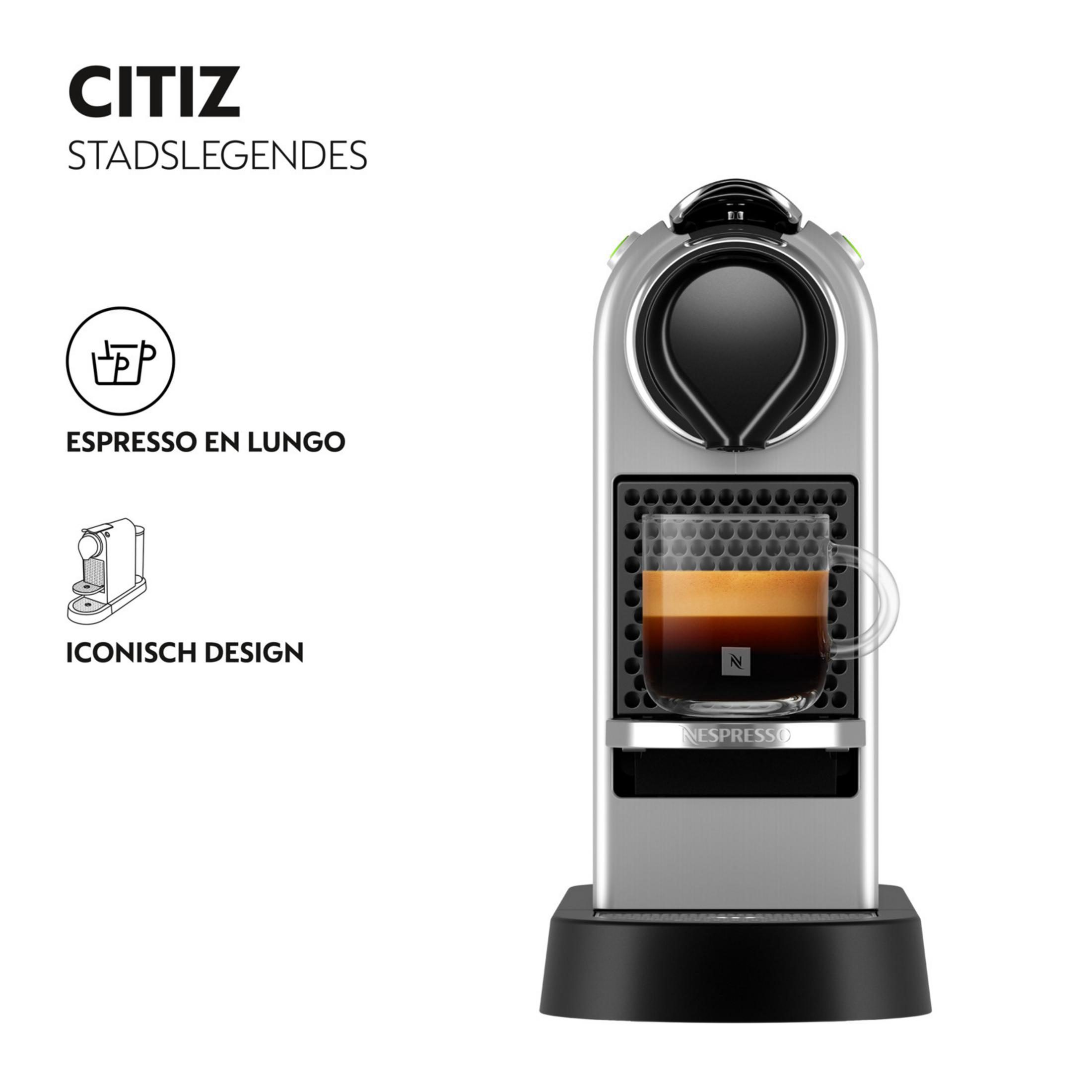 Silver Nespresso coffee machine with espresso in a glass on a white background.