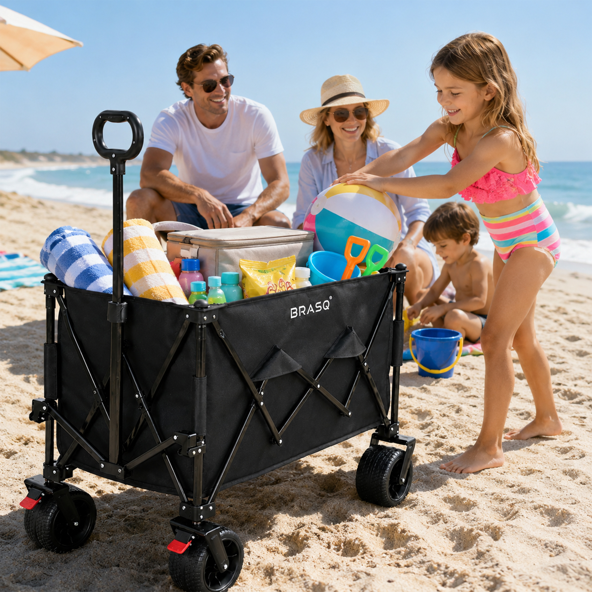 Familie op het strand met bolderkar, koelbox, strandspeelgoed en handdoeken.