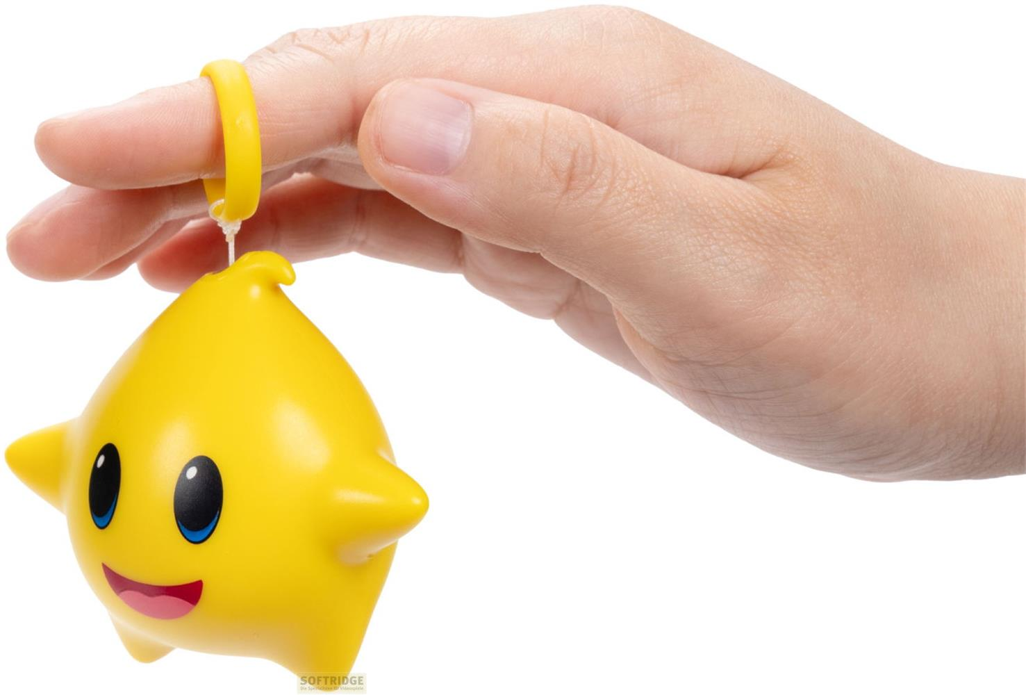 Eine gelbe Stern-Figur mit Gesicht, gehalten von einer Hand mit einem gelben Ring.
