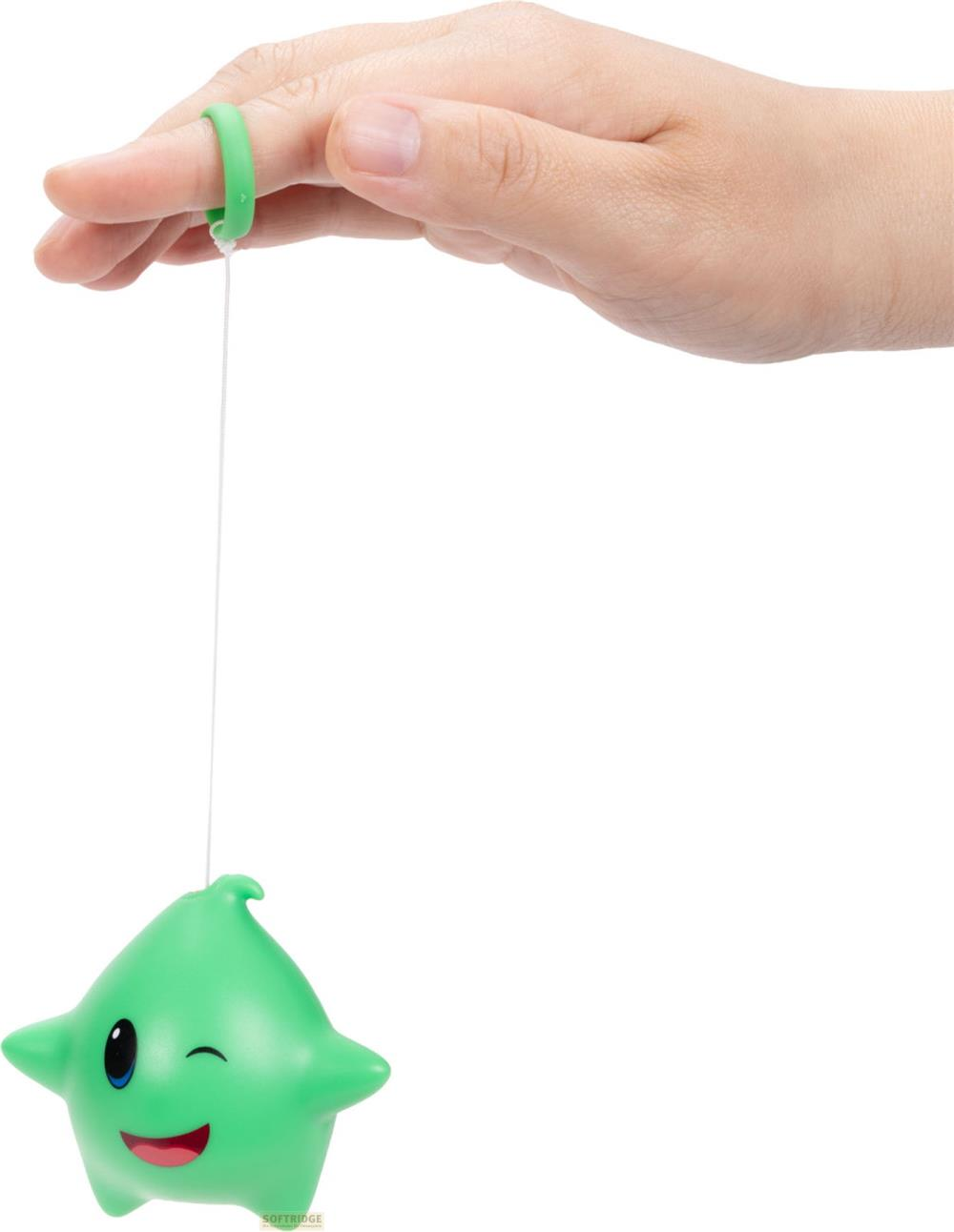 Ein grünes sternförmiges Spielzeug mit Gesicht hängt an einer Schnur, die an einem Finger befestigt ist.