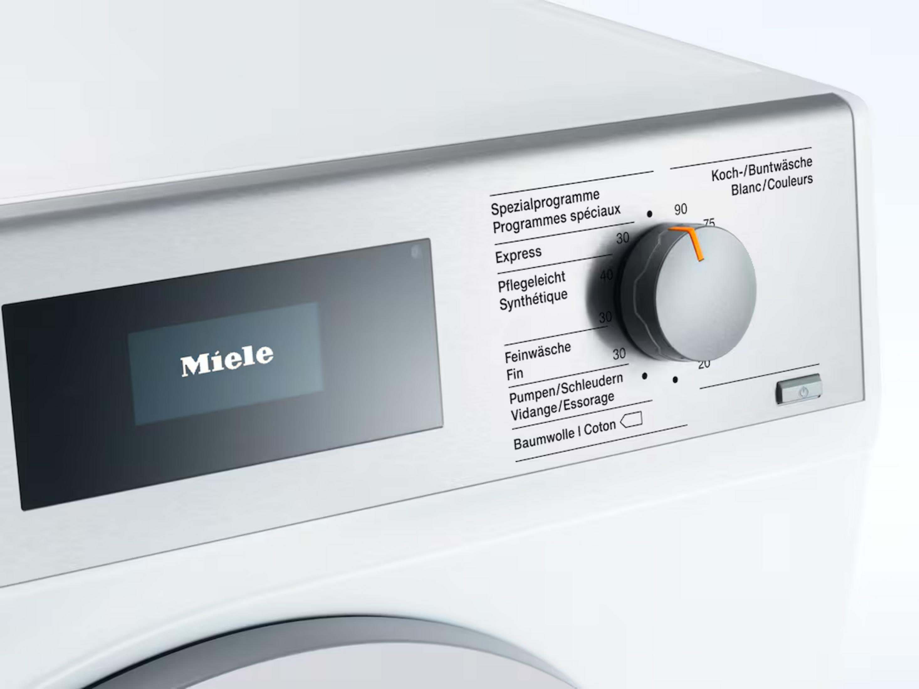 Nahaufnahme einer weißen Miele Waschmaschine mit einem Display und einem Drehregler.