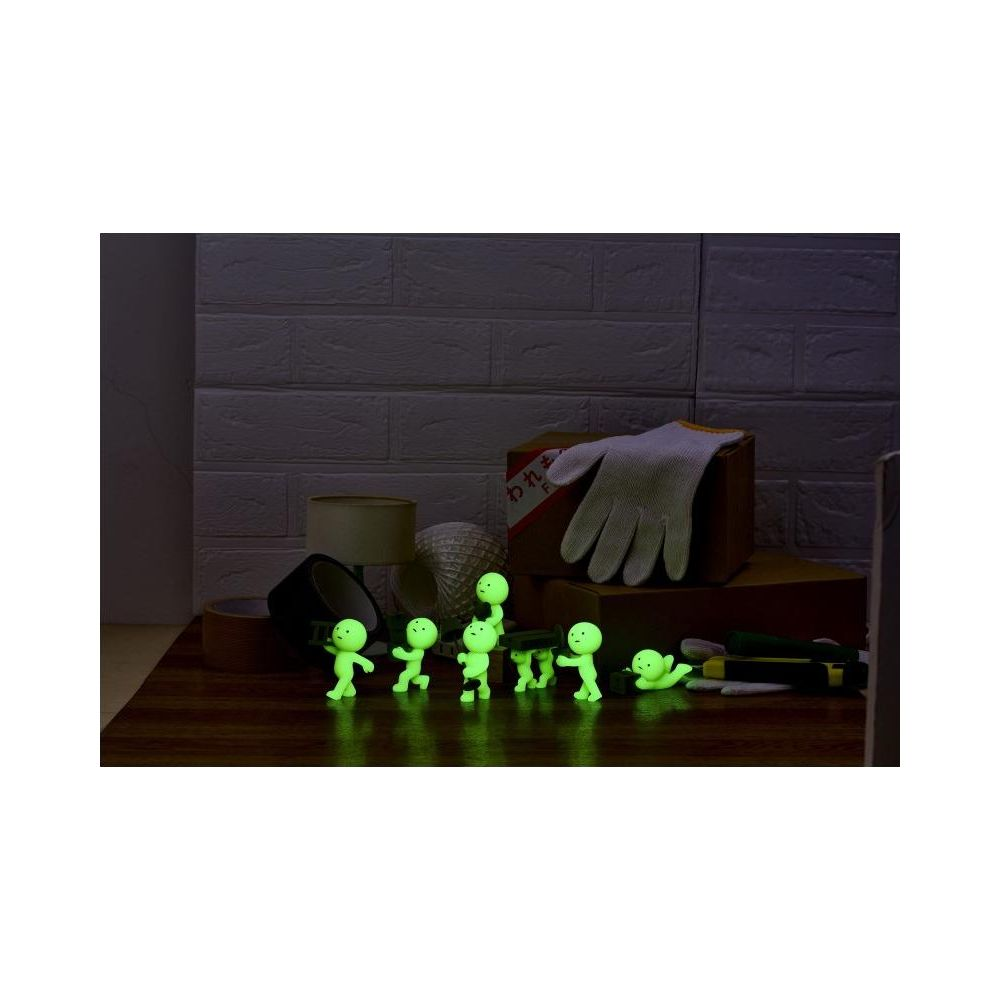 Leuchtende Figuren stehen vor Werkzeug und Handschuh auf einem Holztisch.