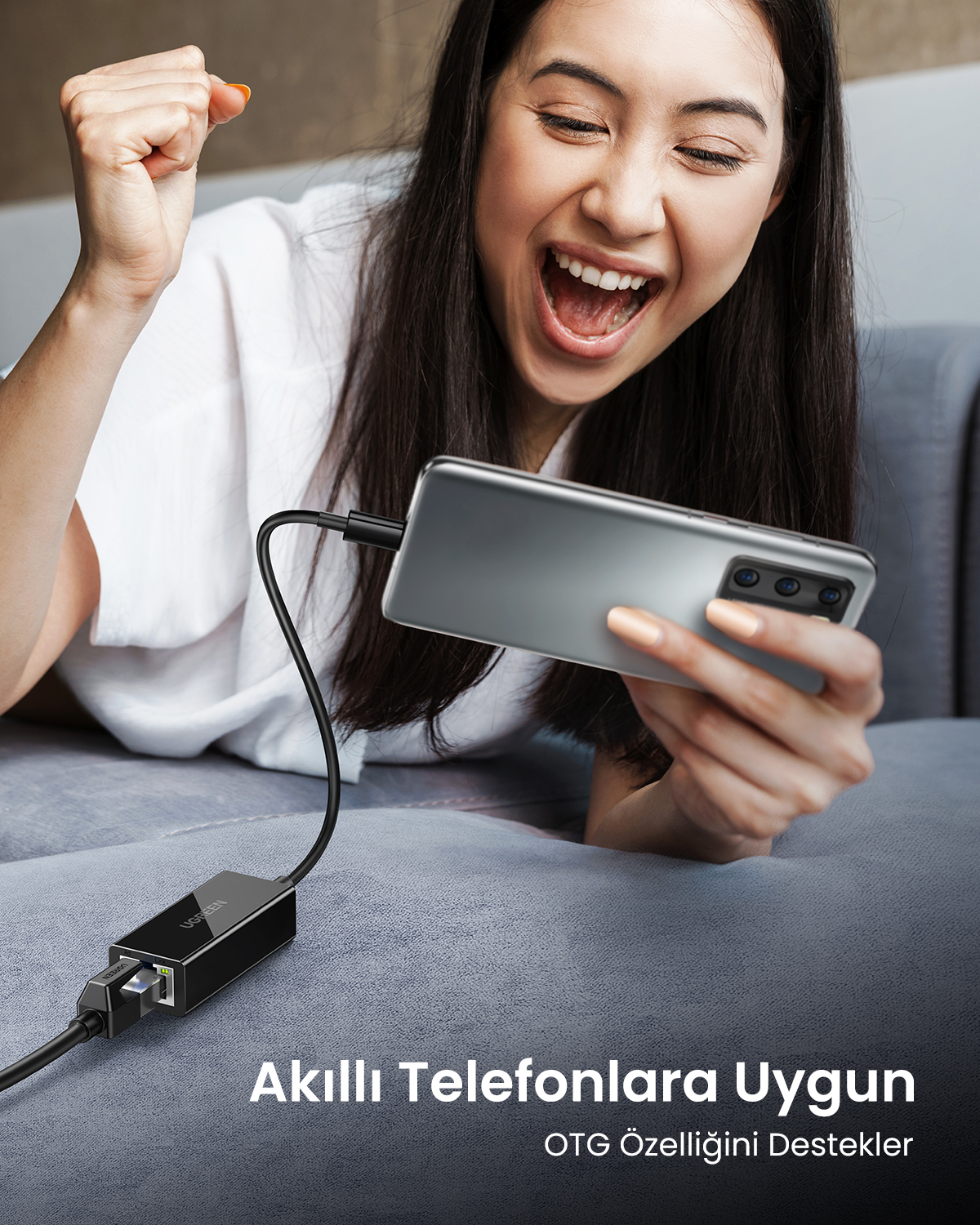 OTG adaptörlü akıllı telefon kullanan bir kadın seviniyor.