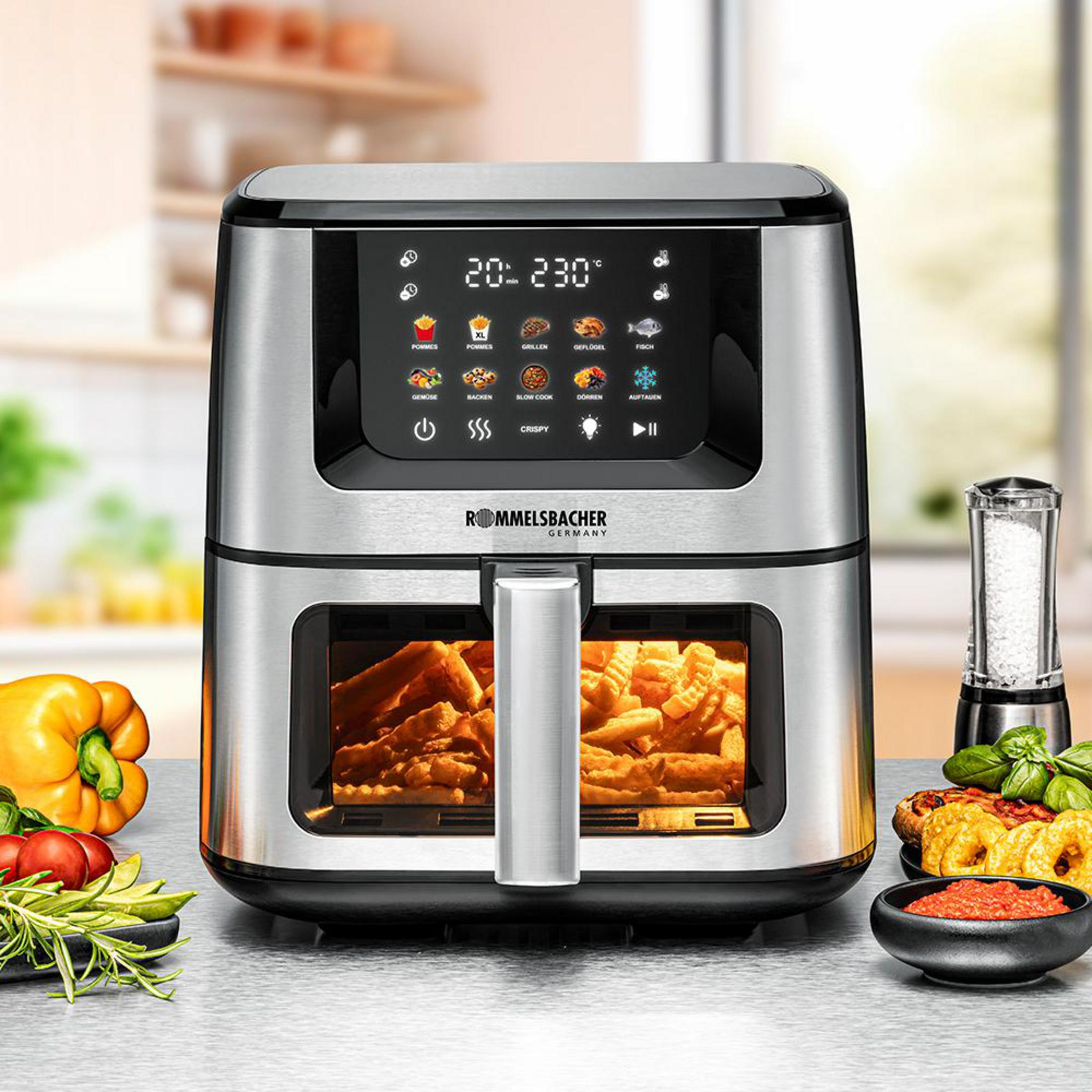Edelstahl-Heißluftfritteuse mit Touchscreen und Kochprogrammen, daneben Gemüse, Dip und Salzstreuer.