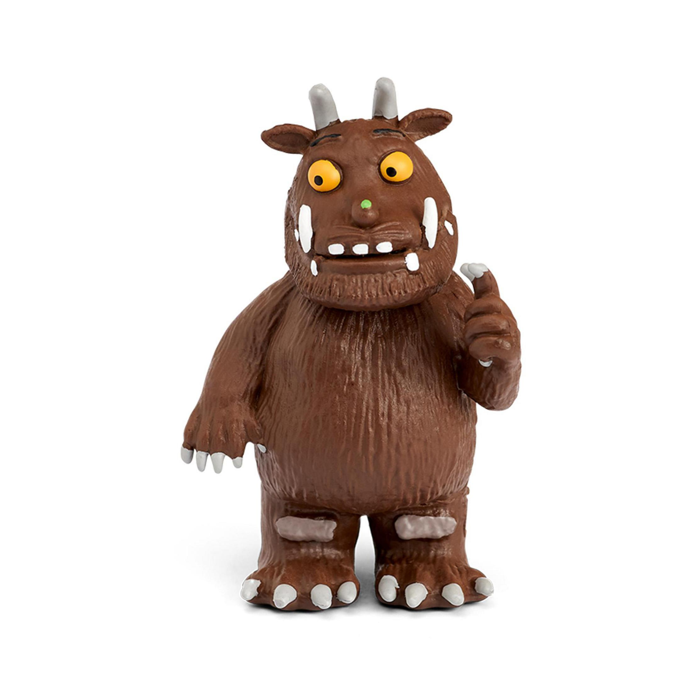 Braune Figur mit Hörnern, gelben Augen und weißen Zähnen, die den Zeigefinger hebt.