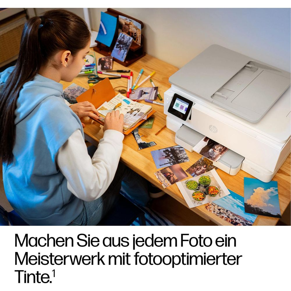 Ein Mädchen bastelt ein Album mit gedruckten Fotos neben einem HP Drucker.
