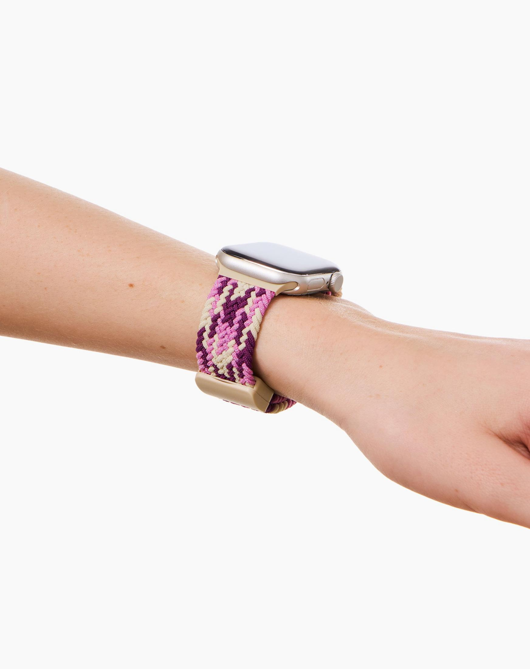 Ein silbernes Apple Watch mit einem bunten Armband an einem Arm.