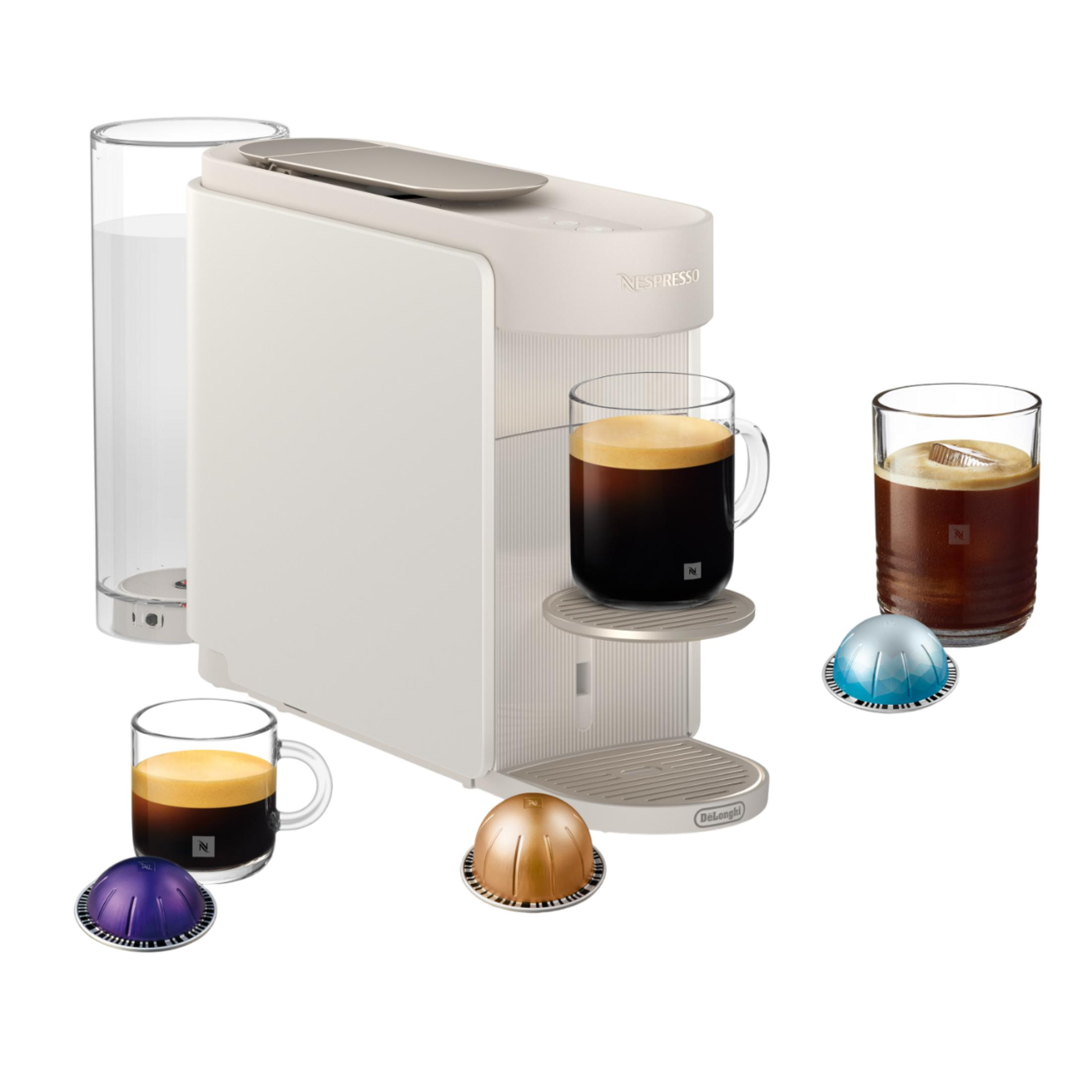 Eine weiße Kaffeemaschine mit zwei Tassen Kaffee, einer Wasserflasche und Kapseln.