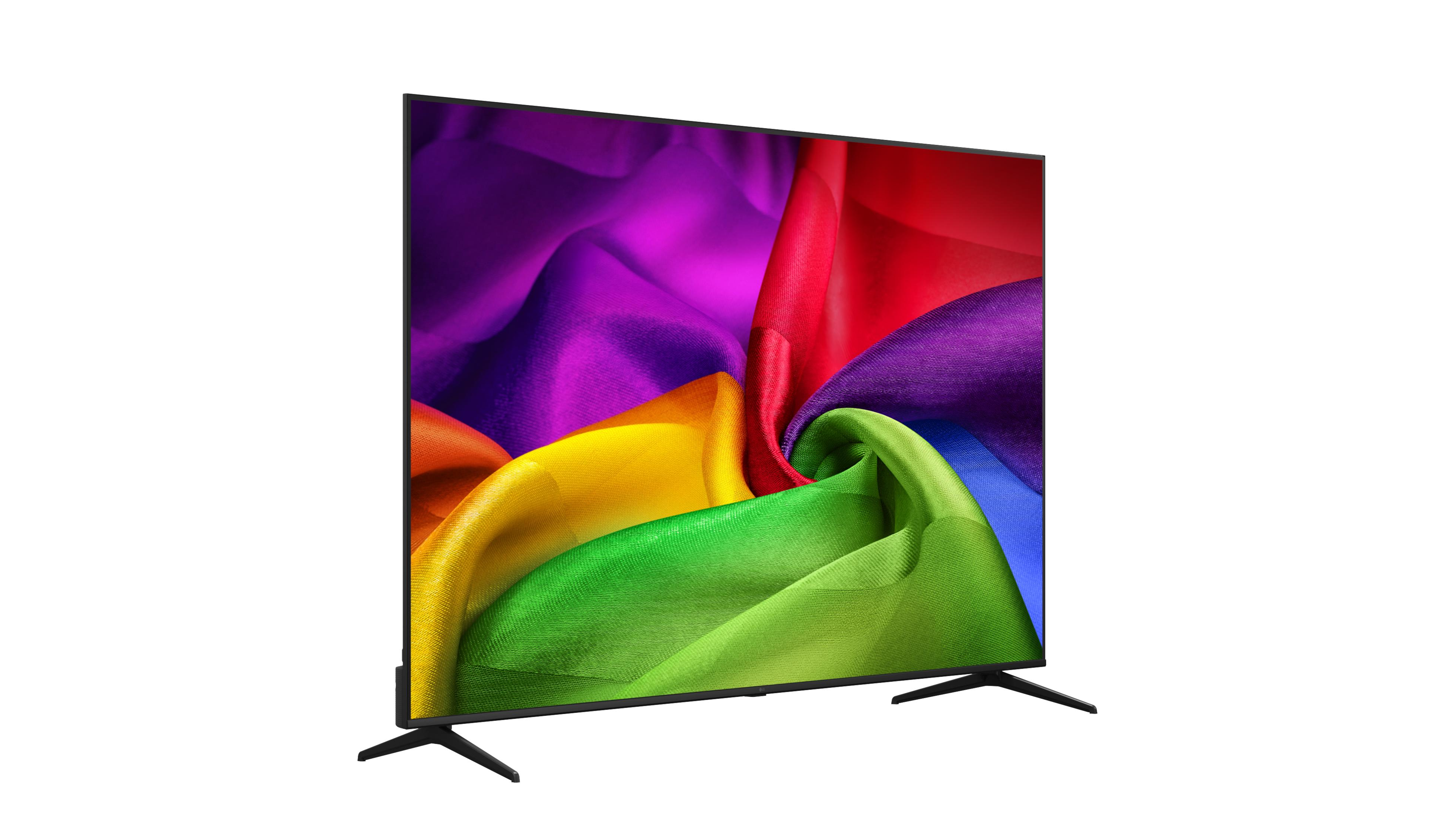 Ein moderner Flachbildfernseher zeigt lebendigen, fließenden Stoff in Regenbogenfarben: Lila, Rot, Gelb, Grün.