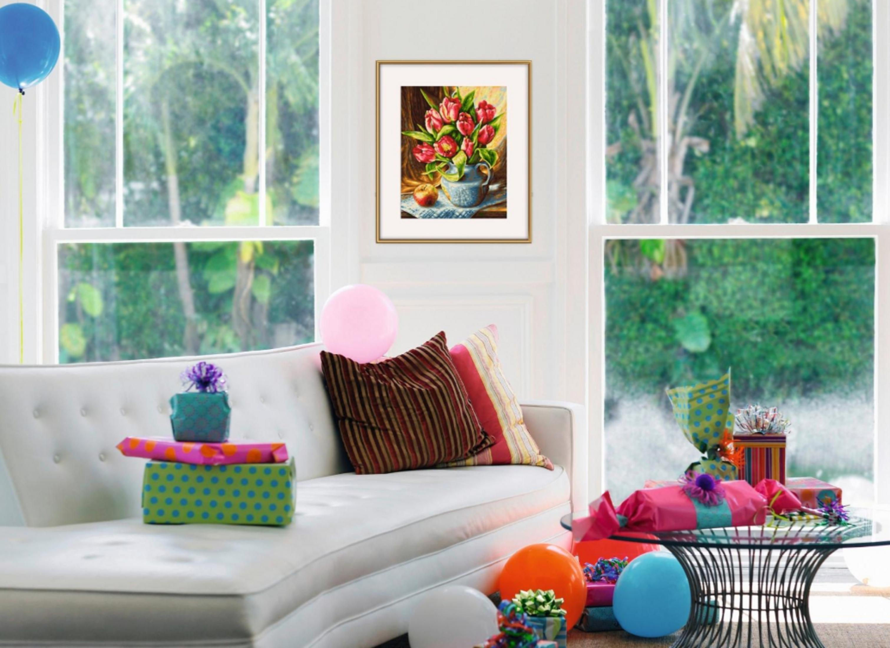 Ein Sofa mit Geschenken und Ballons vor Fenstern mit Blick auf Grün.