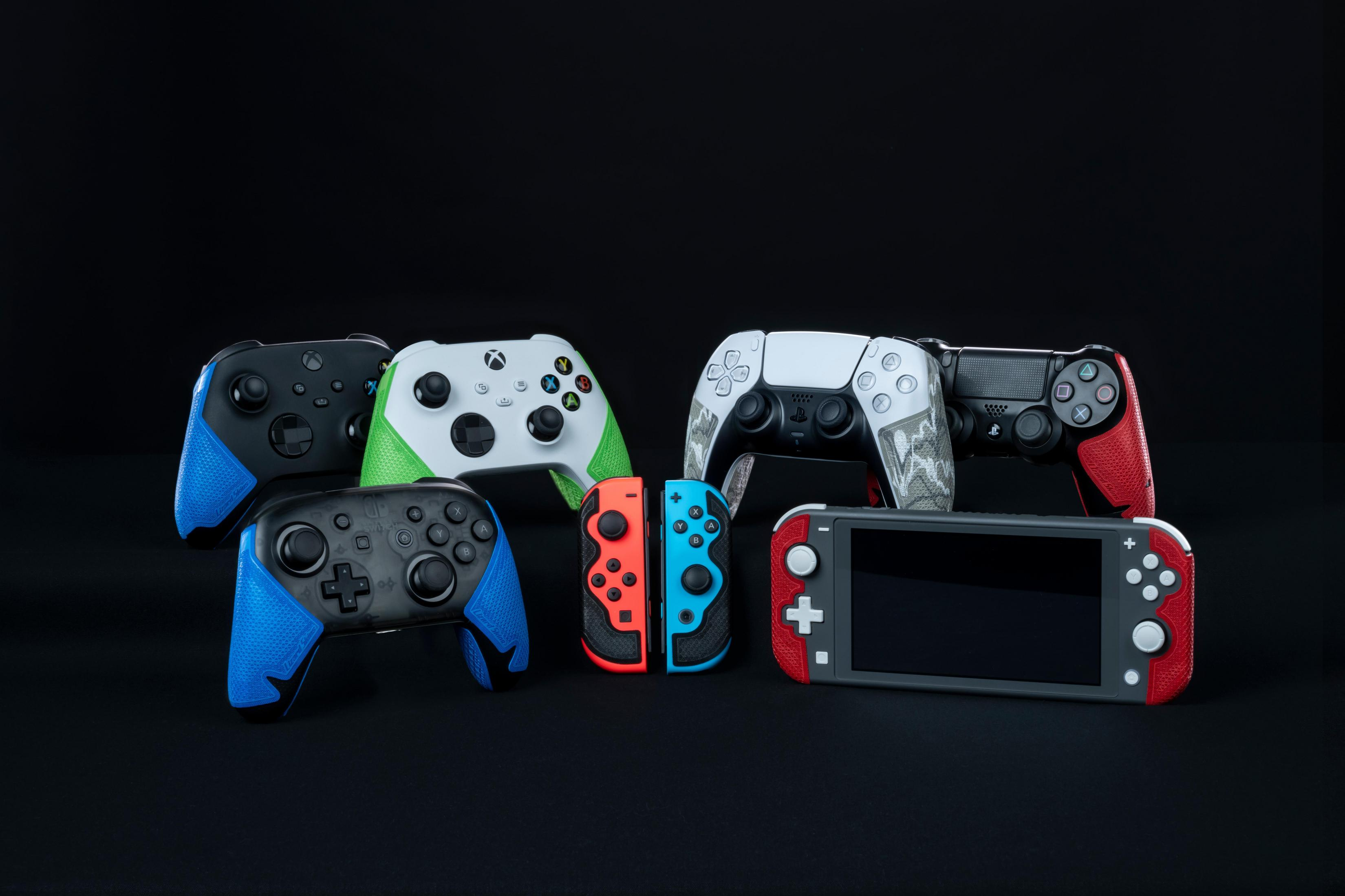 Verschiedene Gaming-Controller und ein Nintendo Switch Lite auf schwarzem Hintergrund.