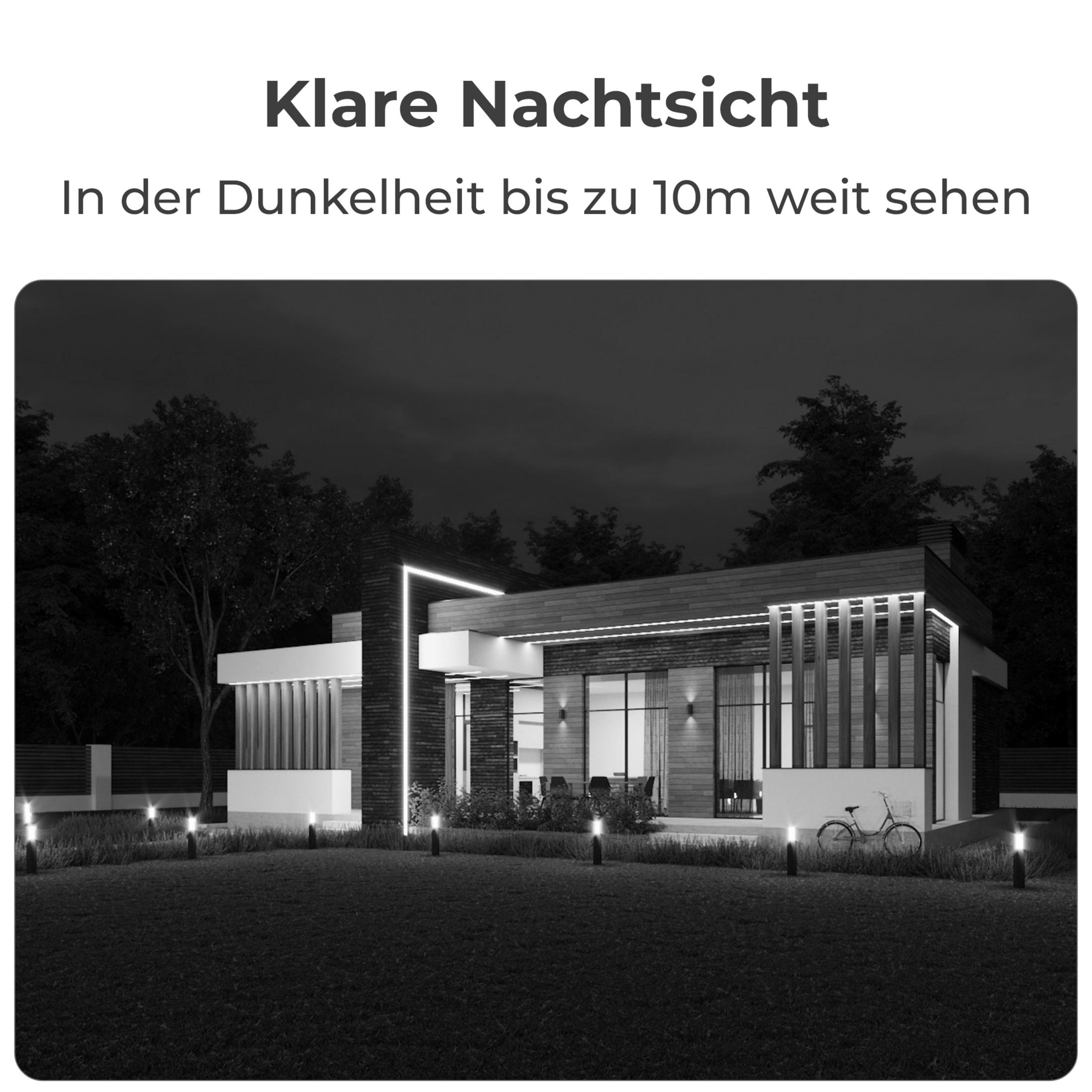 Une maison moderne la nuit avec éclairage extérieur et un vélo.