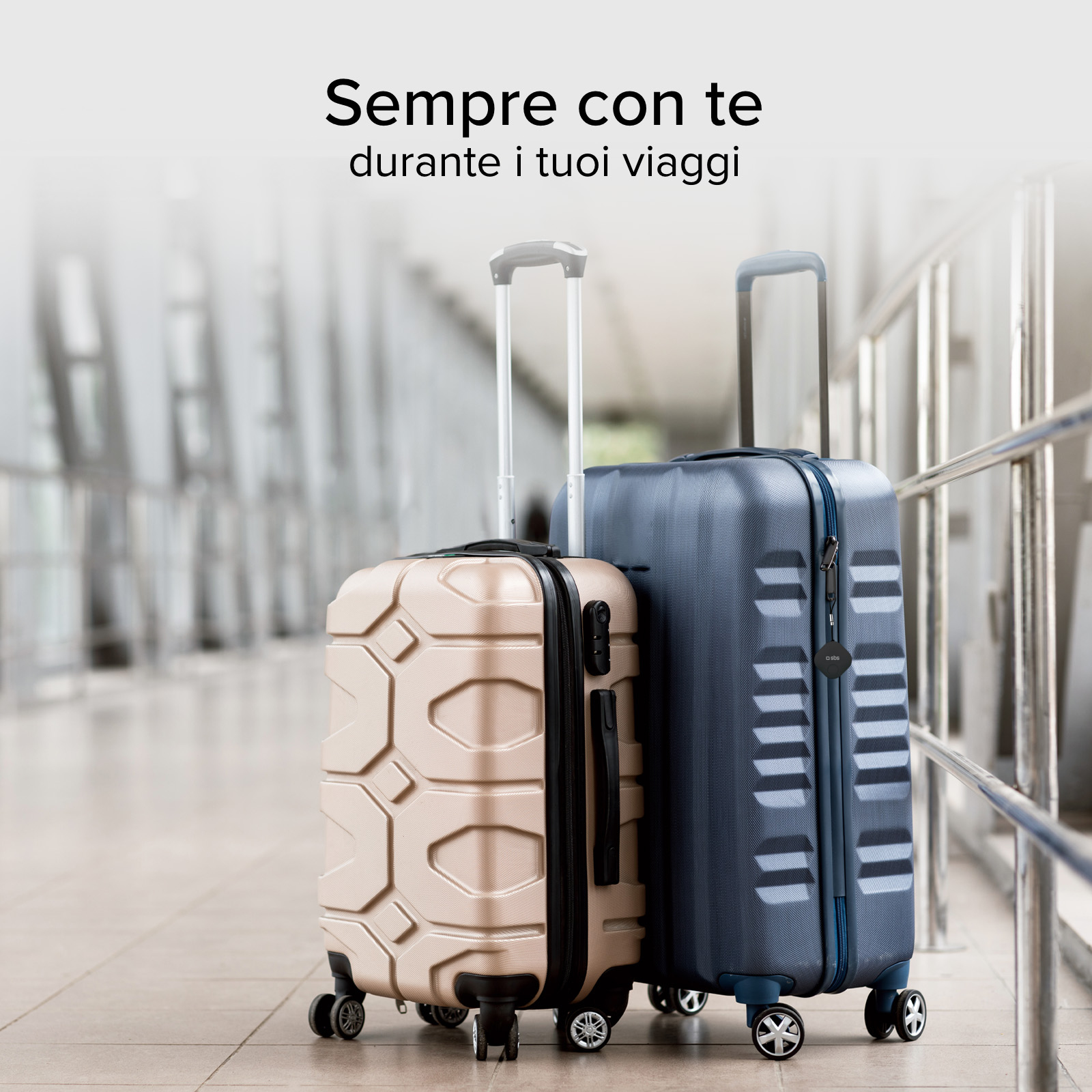 Dos maletas con ruedas, una beige y una azul, están en un pasillo.