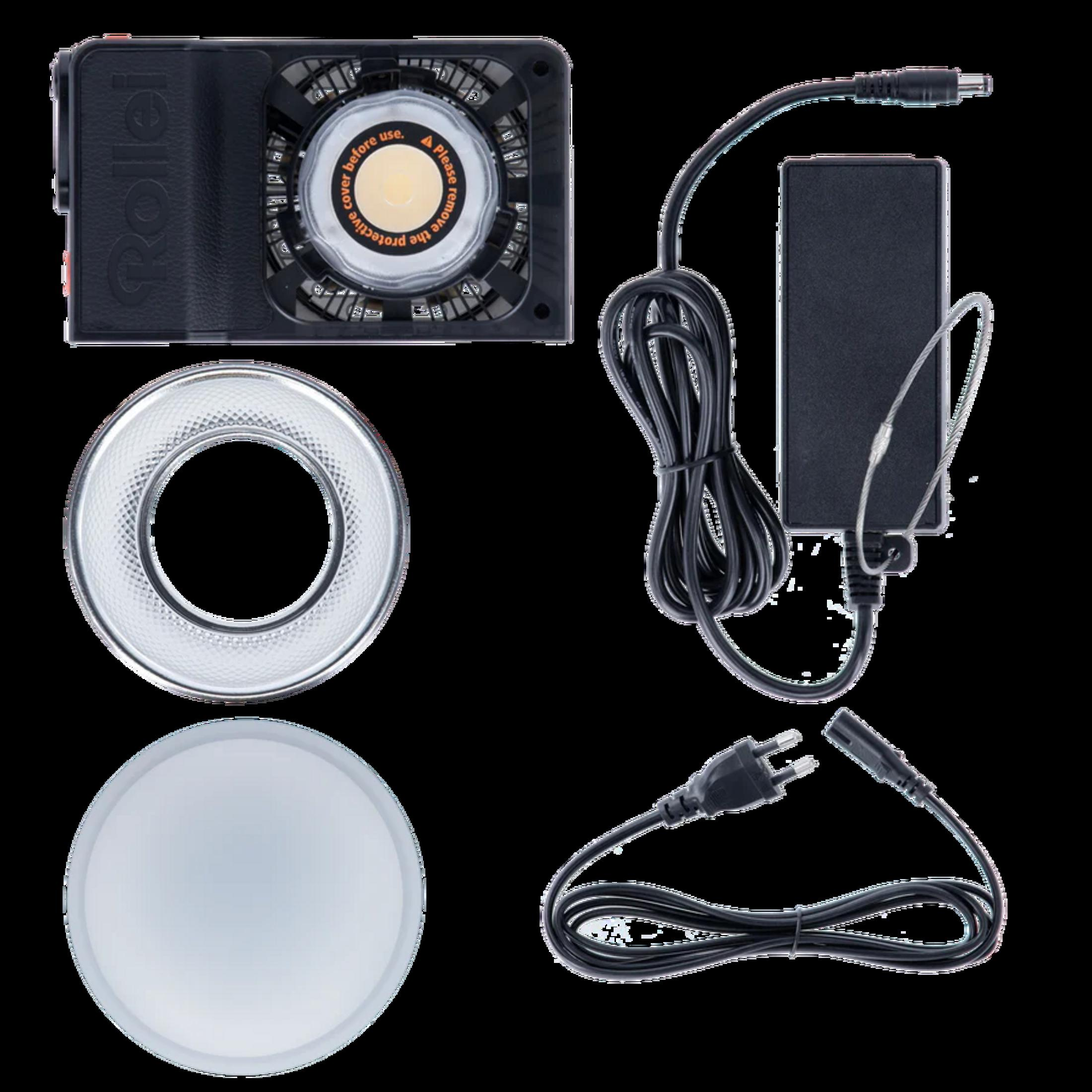 Ein Rollei LED-Ringlicht mit Netzteil und Kabeln auf schwarzem Hintergrund.