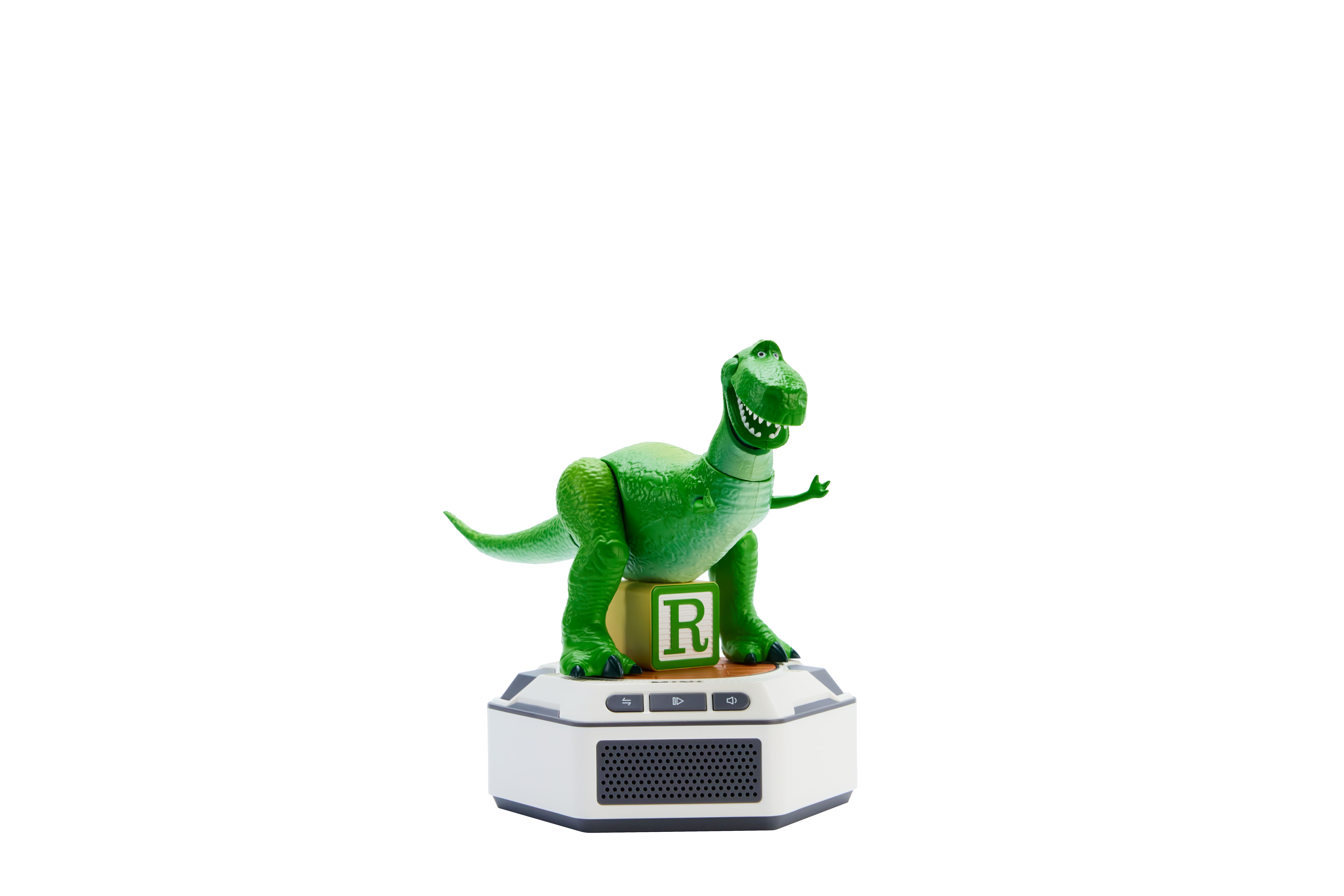 Juguete de dinosaurio verde sobre un dispositivo blanco con bloque 'R'.