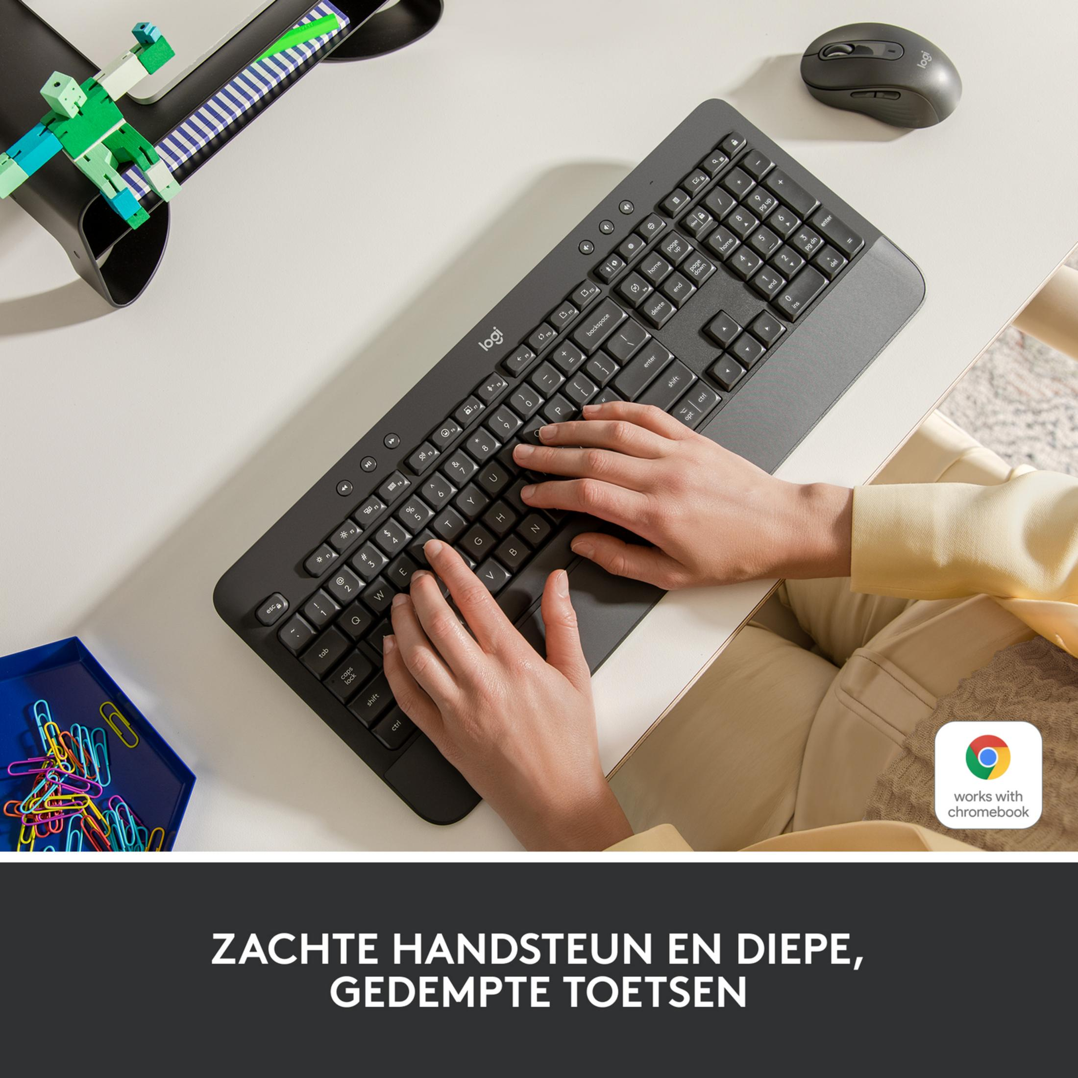 Una persona digita su una tastiera Logitech scura con un mouse accanto.