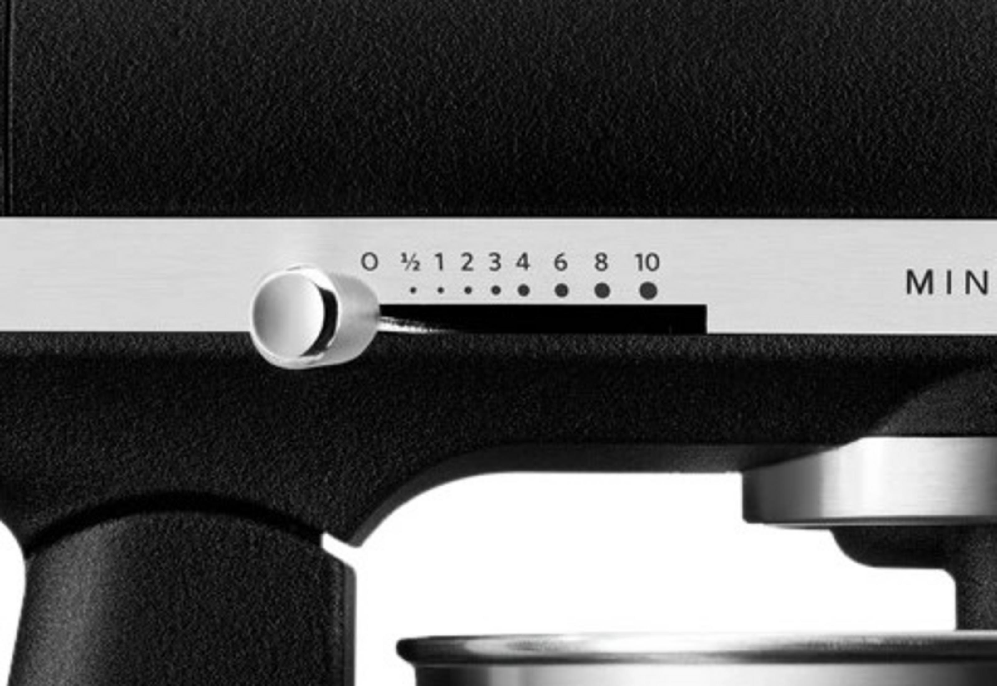 Schwarzer Mixer mit Geschwindigkeitsregler (0-10), auf 2 eingestellt. Müslischale sichtbar.