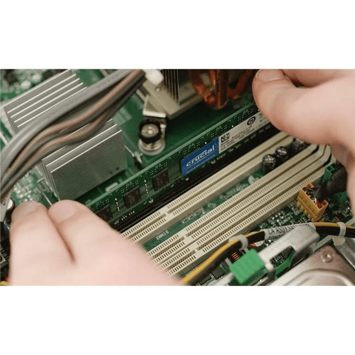 Manos instalando una memoria RAM en una placa base de ordenador.