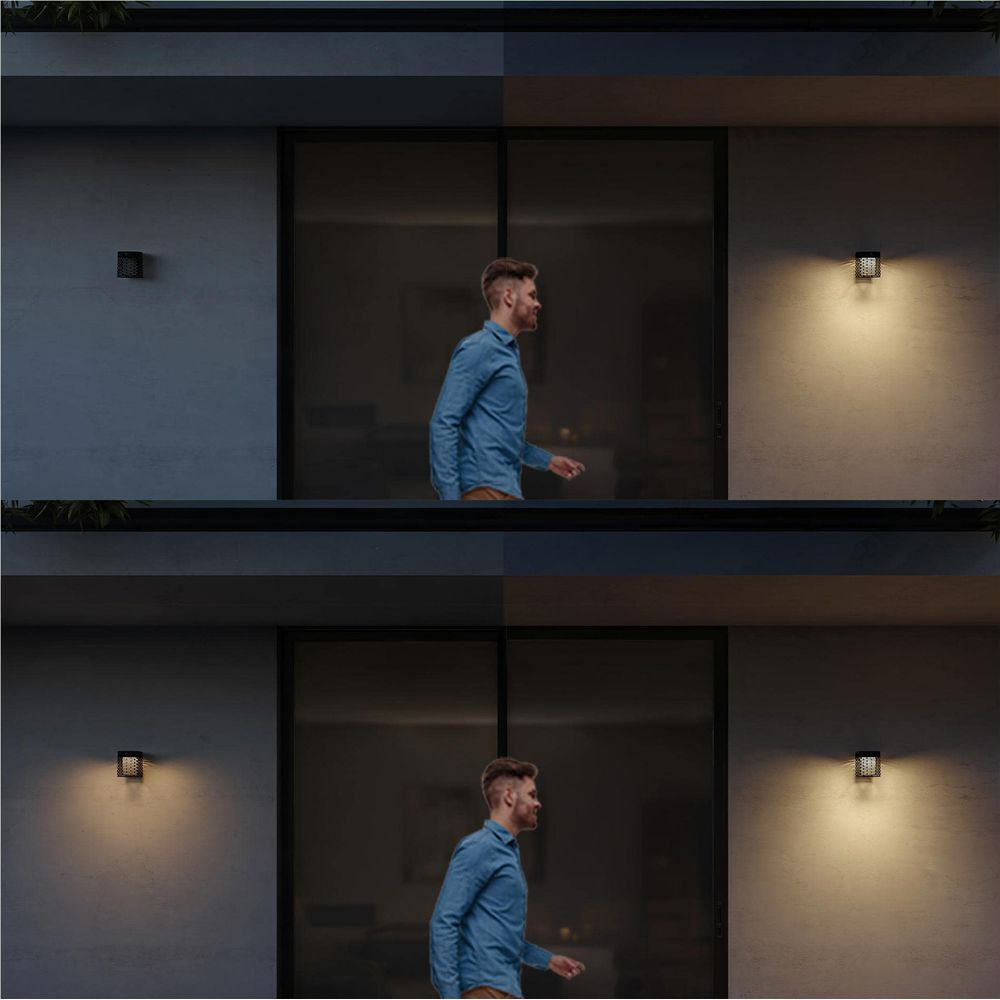 Hombre con camisa azul pasa junto a pared con lámpara. Arriba y abajo.