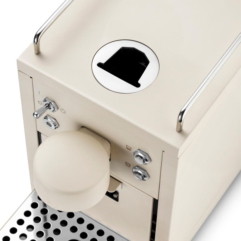 Macchina da caffè color crema con accenti cromati, leva, pulsanti e vassoio raccogligocce.