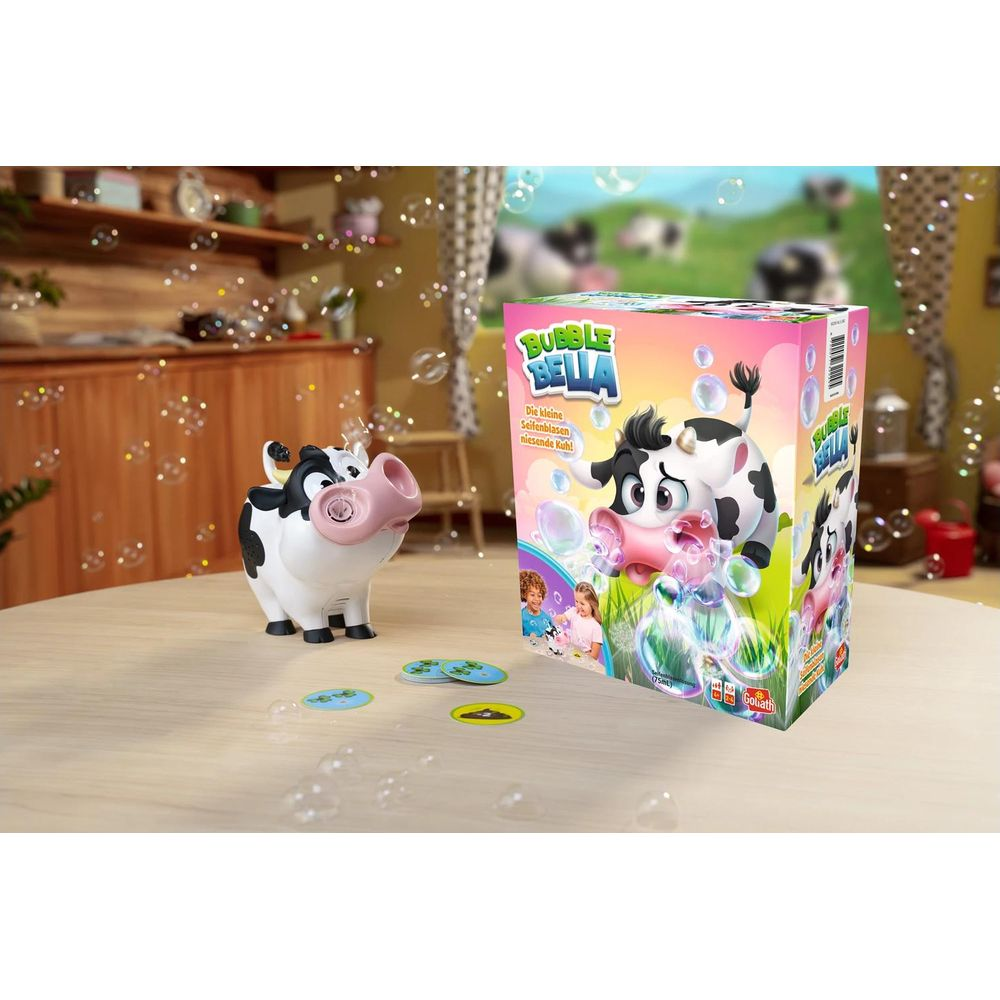 Vache jouet soufflant des bulles à côté de la boîte de jeu sur une table.