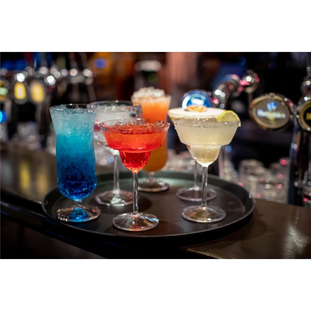Fünf Cocktails auf einem Tablett: blau, rot, orange und zwei helle.