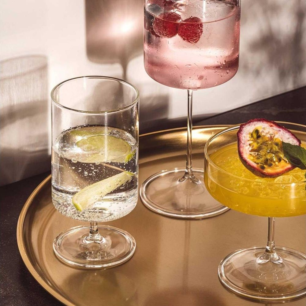 Drei Cocktails auf einem Tablett: eins mit Limette, eins mit Himbeeren, eins mit Passionsfrucht.