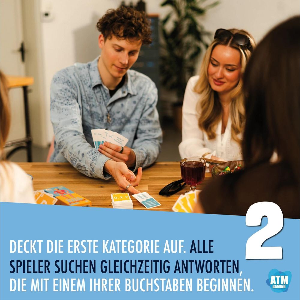 Zwei junge Leute spielen ein Kartenspiel an einem Holztisch mit Getränken und Karten.